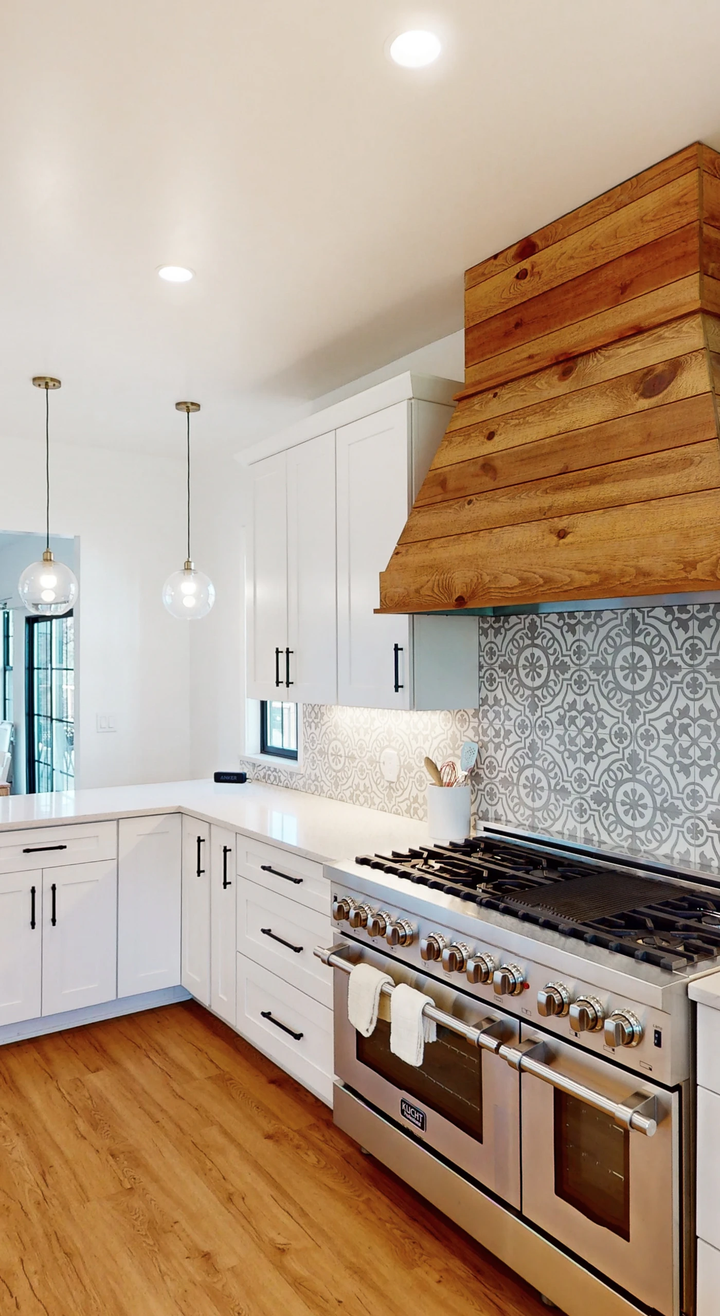 Fire up the professional-style gas range beneath a gorgeous reclaimed wood hood — patterned tile and gleaming quartz create your dream kitchen for crafting wine-paired dinners.