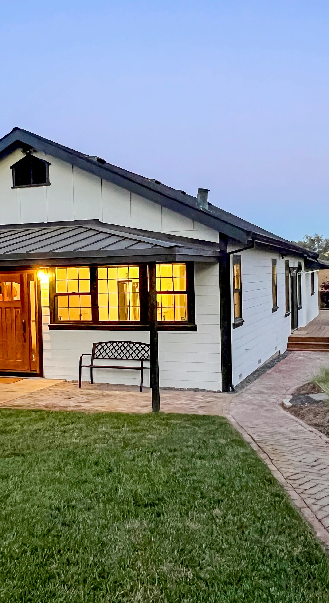Welcome to your modern farmhouse escape in Penngrove — warm interior light spills through black-framed windows as a brick path guides you to a beautifully renovated wine country retreat.