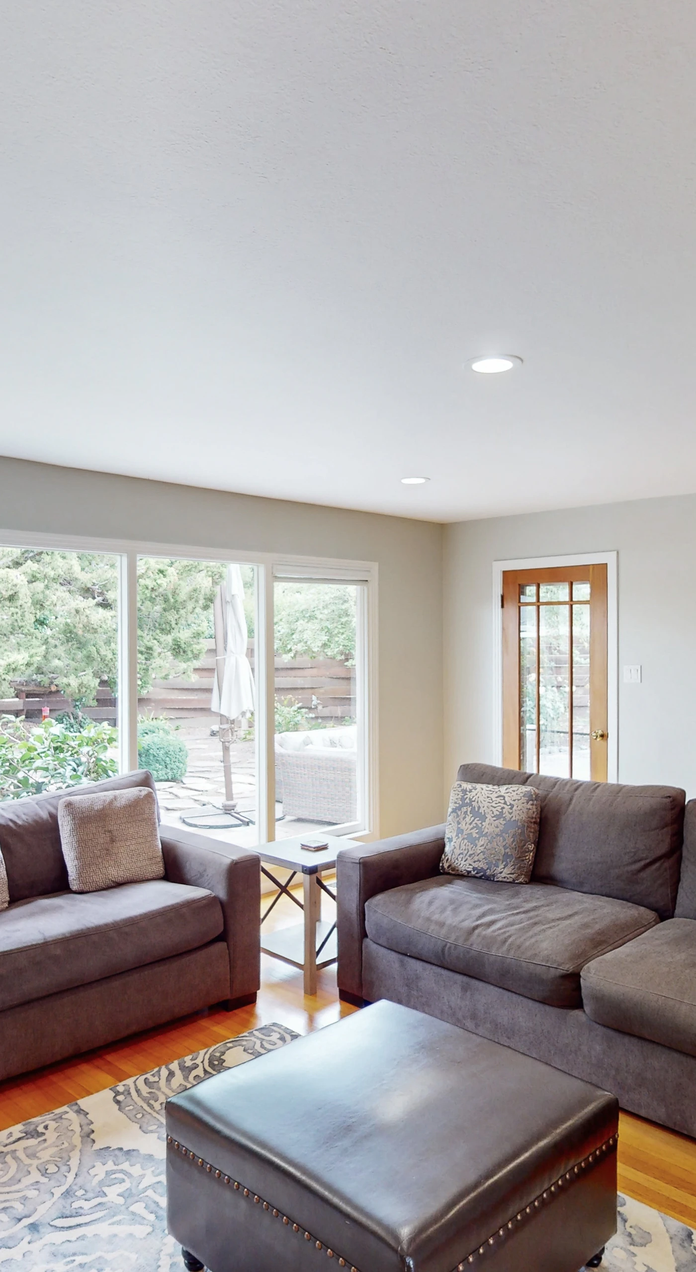 Stretch out in your sun-filled living room where floor-to-ceiling windows frame garden views — hardwood floors and comfortable seating invite you to relax between vineyard visits.