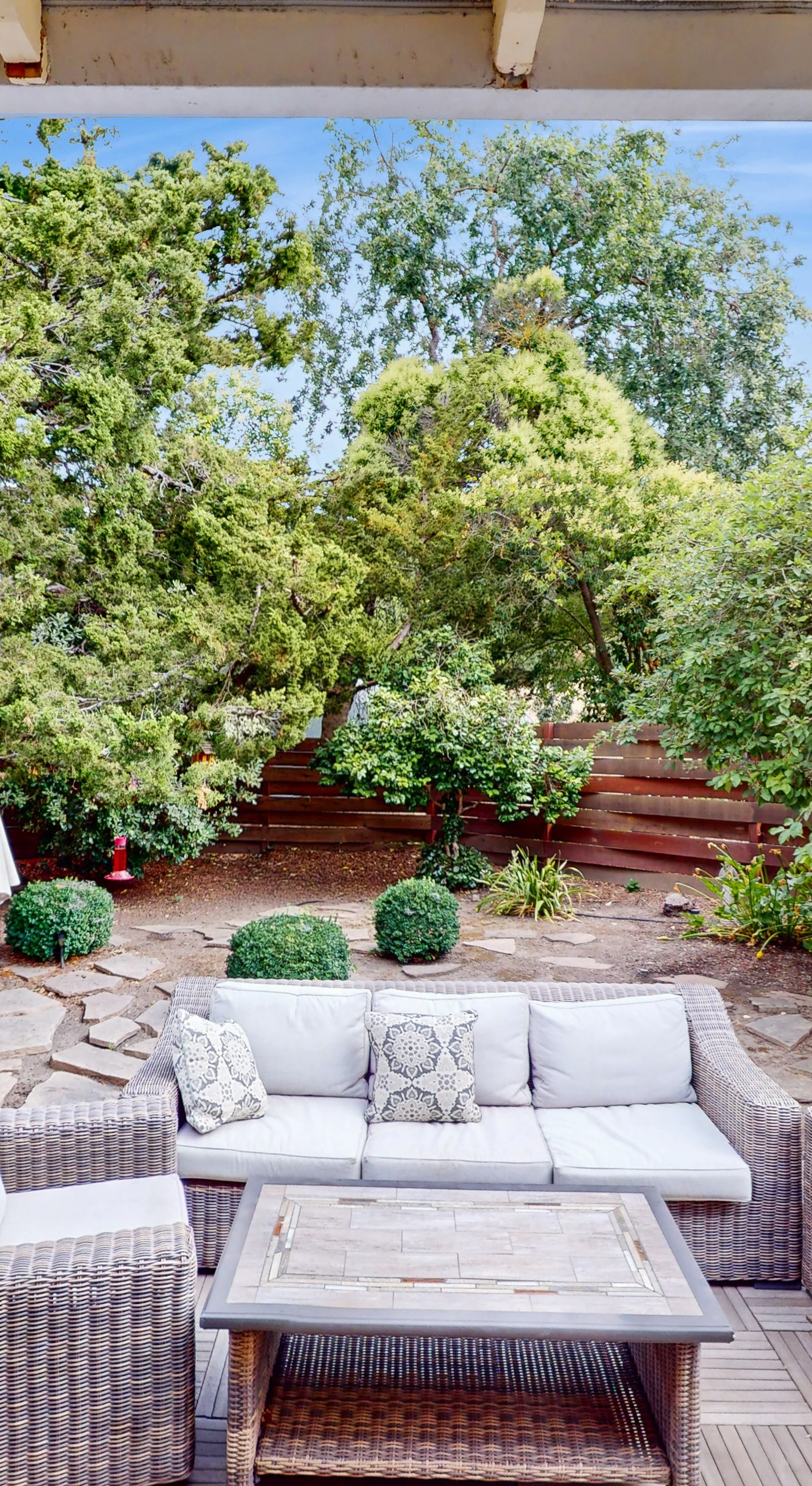 Unwind on your private patio surrounded by lush Sonoma greenery — plush wicker seating and a shaded umbrella create the perfect spot to sip local wines after a day of tasting.