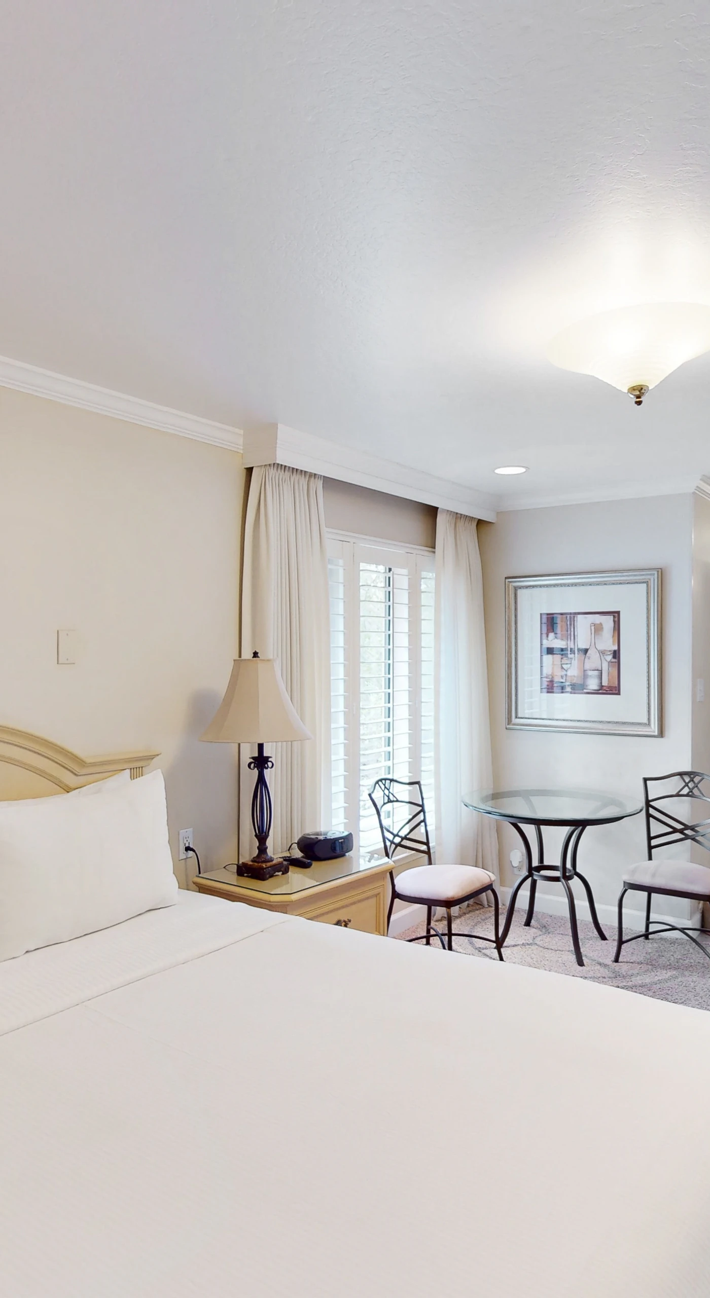 Settle into your elegantly appointed Napa Valley suite featuring a plush king bed, bistro seating area, and soft natural light — your wine country sanctuary awaits.