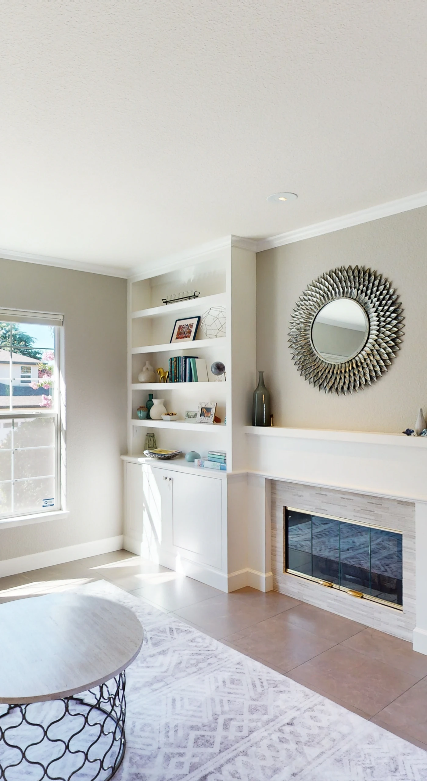 Cozy up by your gas fireplace in this elegant sitting room with built-in bookshelves and picture windows — perfect for a quiet Sonoma evening in.