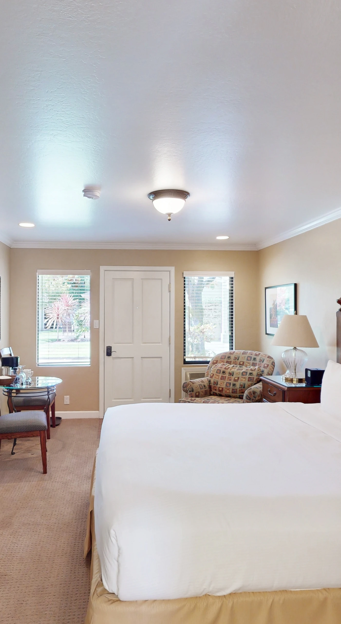 Rest easy in your spacious king bedroom featuring a stately armoire, elegant furnishings, and soft carpeting throughout