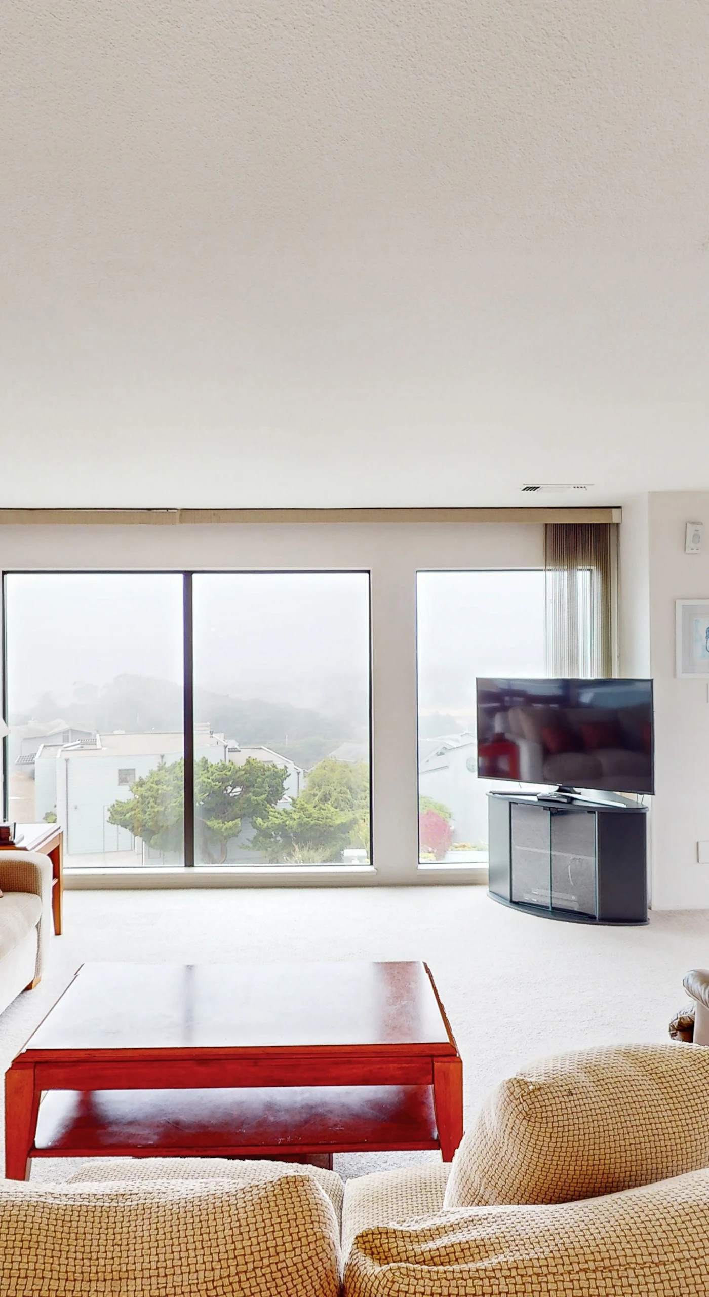 Sink into plush seating in your sunlit living room where panoramic Bodega Bay views stretch beyond floor-to-ceiling windows and a private balcony
