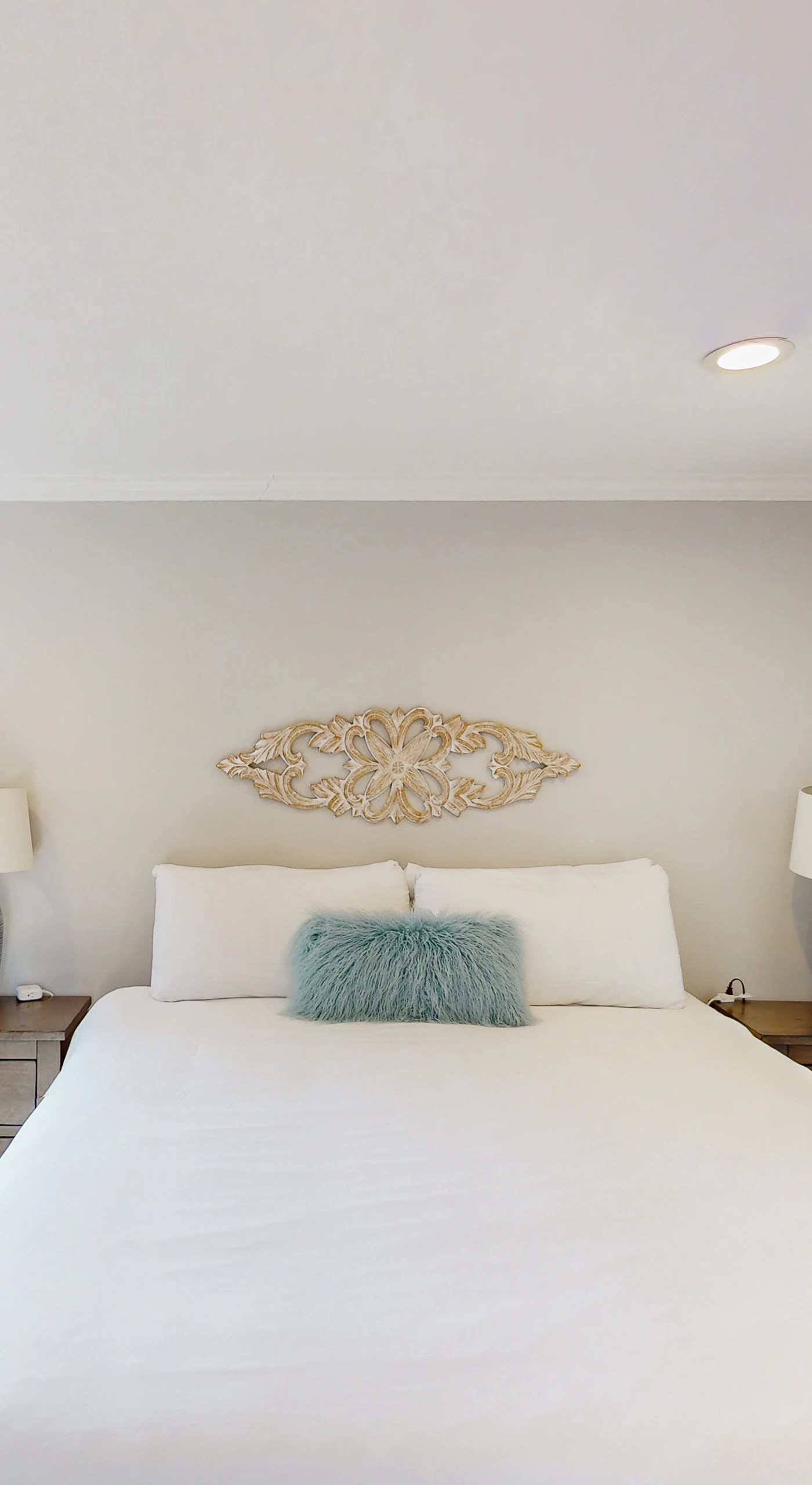 Matching nightstands and soft lighting frame your king bed for cozy evenings — step through the doorway to freshen up in your private en-suite bath