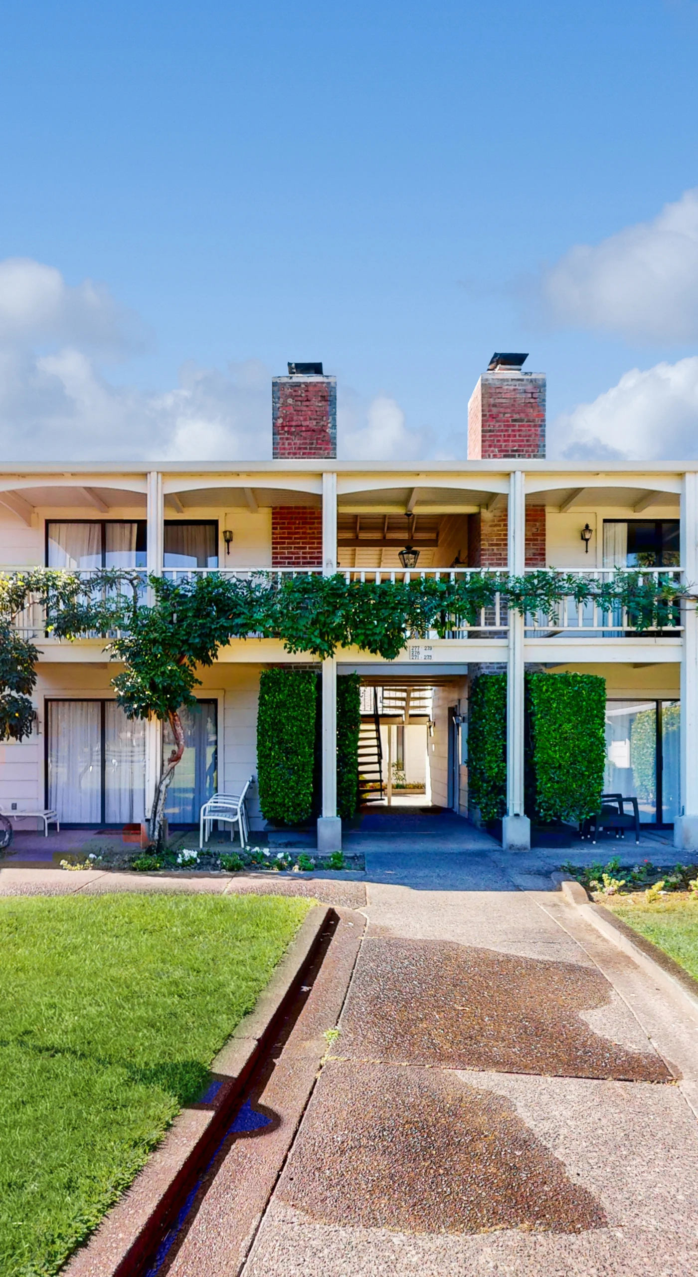 Welcome to your Napa Valley resort retreat — a charming two-story condo with ivy-draped balcony, manicured lawns, and classic lantern-lit walkways at Silverado Resort.