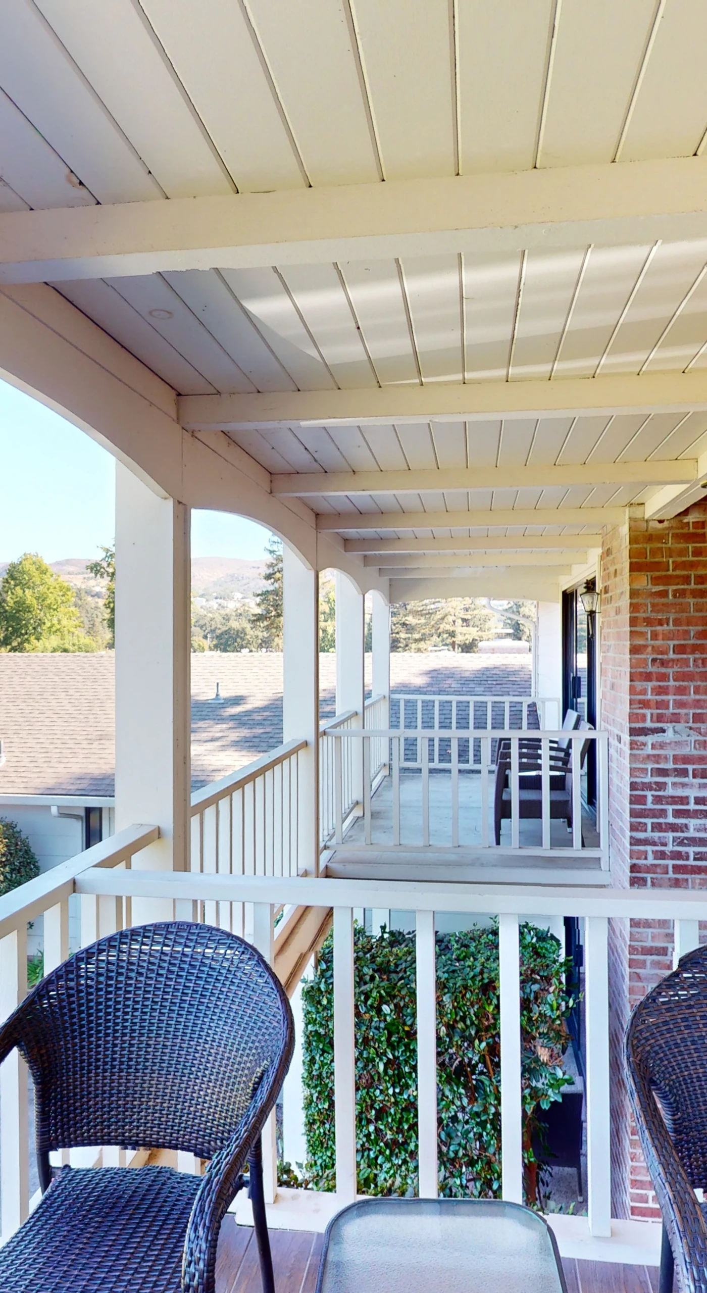 Relax on your covered porch with wicker seating and charming lantern lighting — an inviting spot to enjoy a glass of your favorite Napa pour.