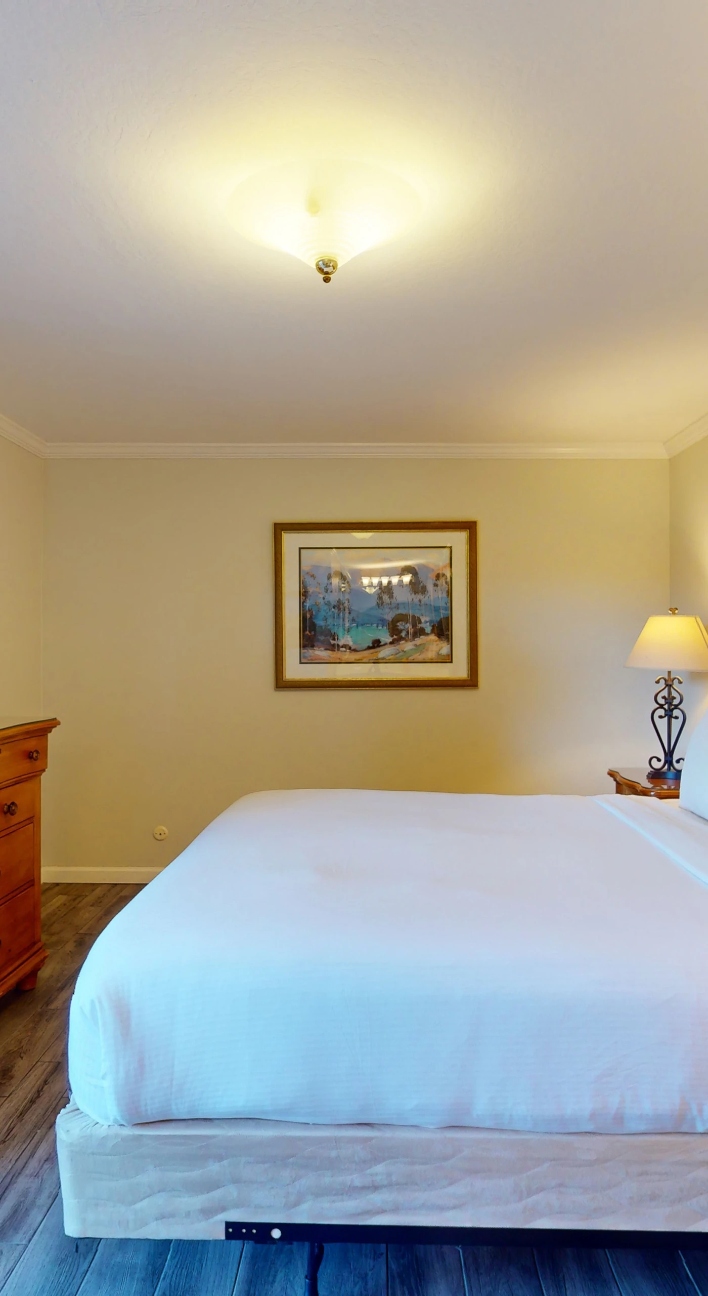 Drift off in crisp white linens atop your king bed, framed by warm wood furnishings that echo Napa Valley's rustic elegance.