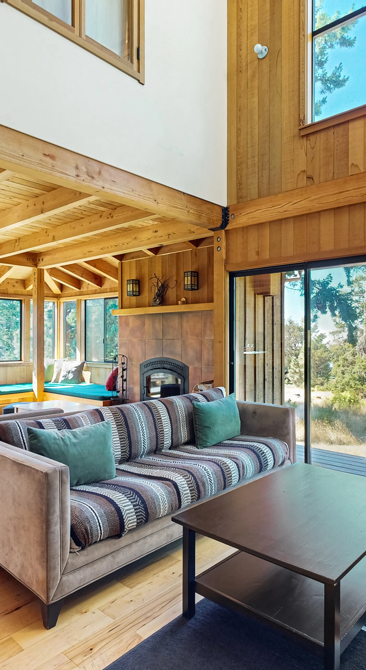 Morning light pours into this inviting living room, perfect for cozy gatherings by the wood-burning fireplace.