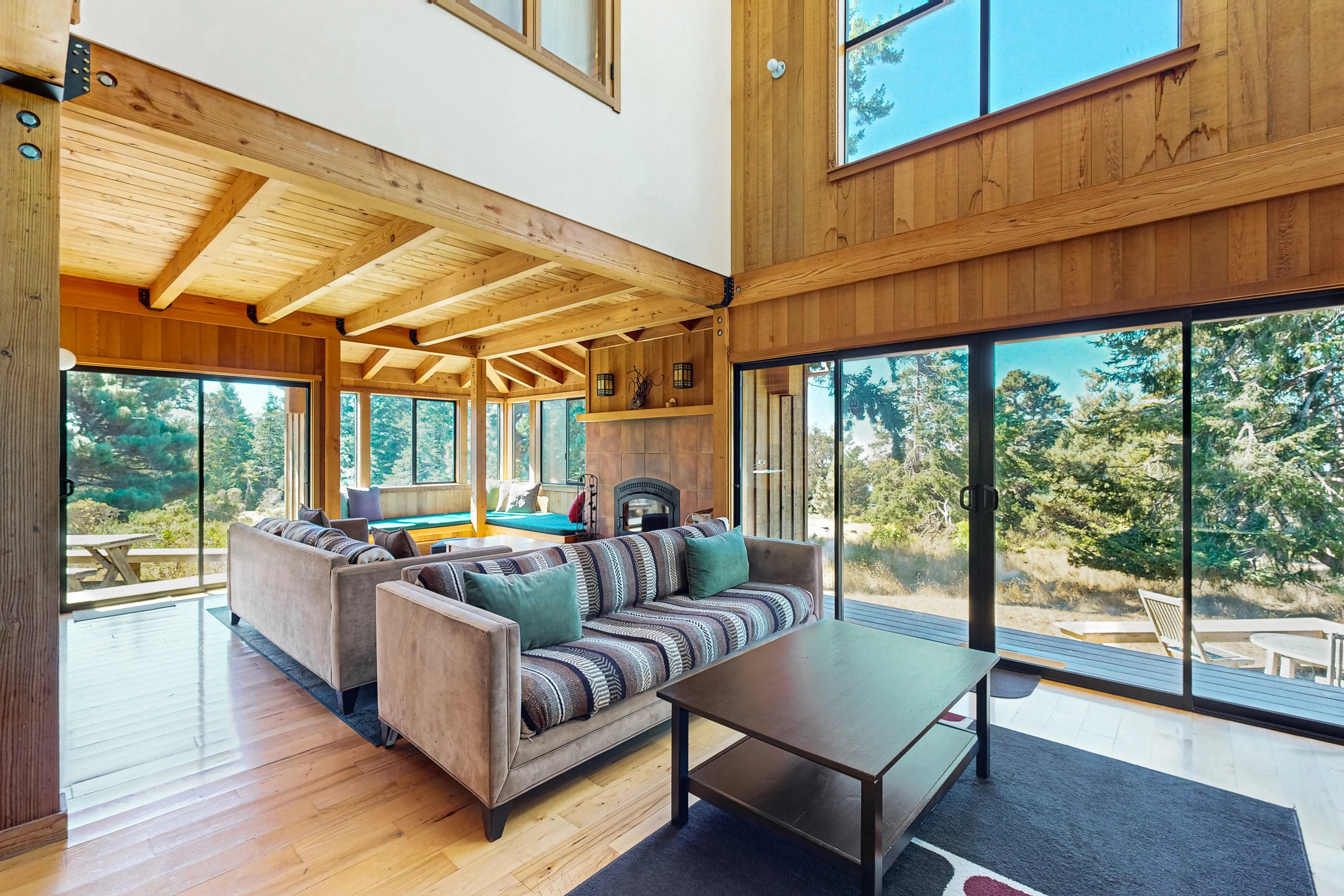 Morning light pours into this inviting living room, perfect for cozy gatherings by the wood-burning fireplace.