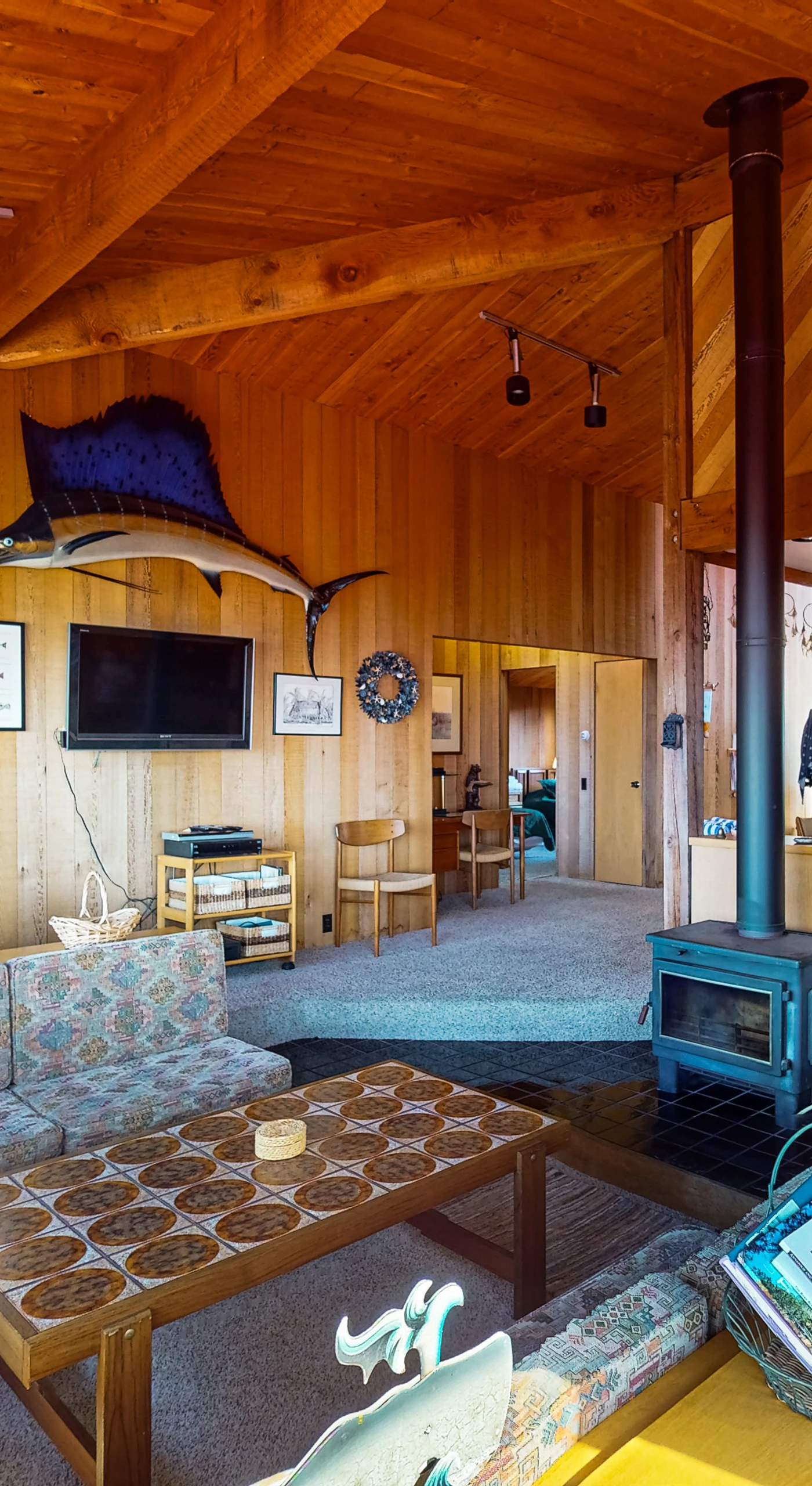 Gather around the cozy living space, where warm wood accents and a wood stove create the perfect ambiance for relaxation.