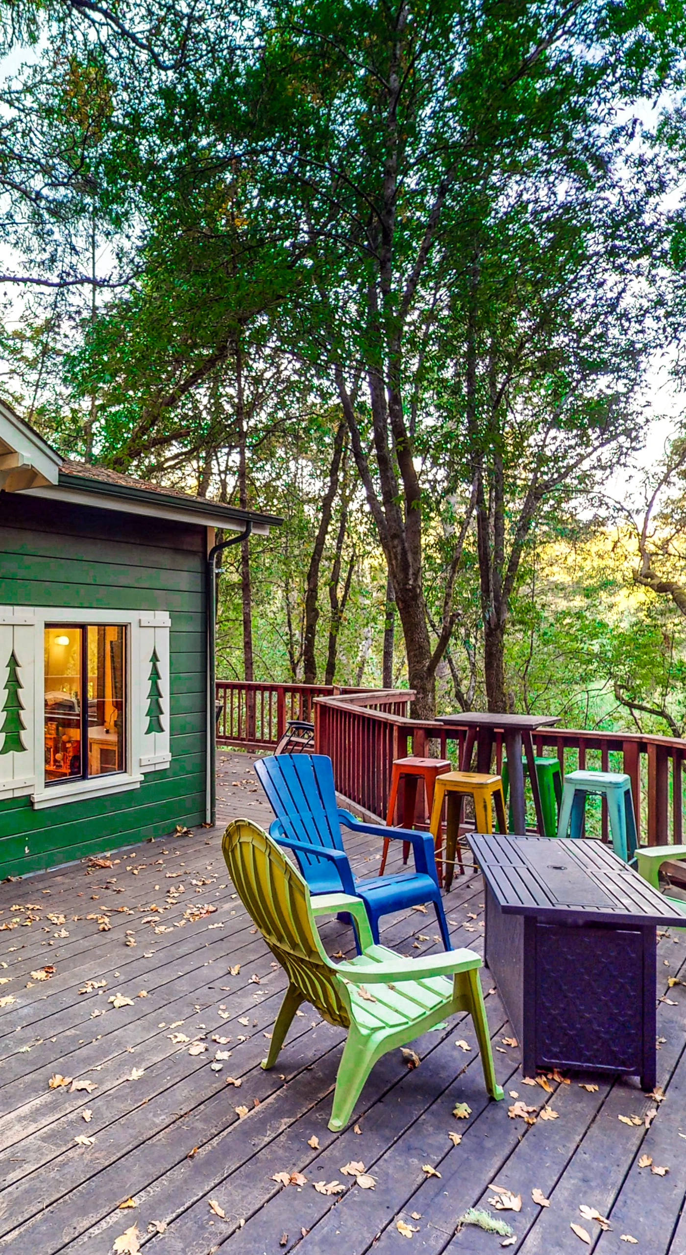 Gather around your private deck beneath the Russian River redwood canopy — colorful Adirondack chairs and a round table set the scene for wine country evenings under the stars.