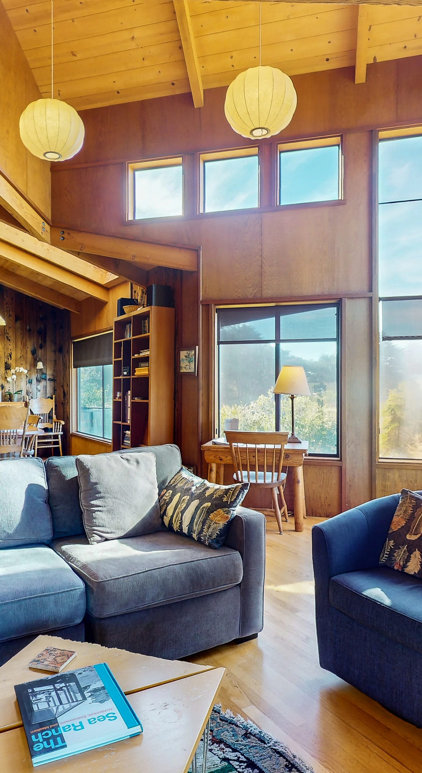 Natural light floods the living room, highlighting stunning ocean views and creating an inviting space for family gatherings.