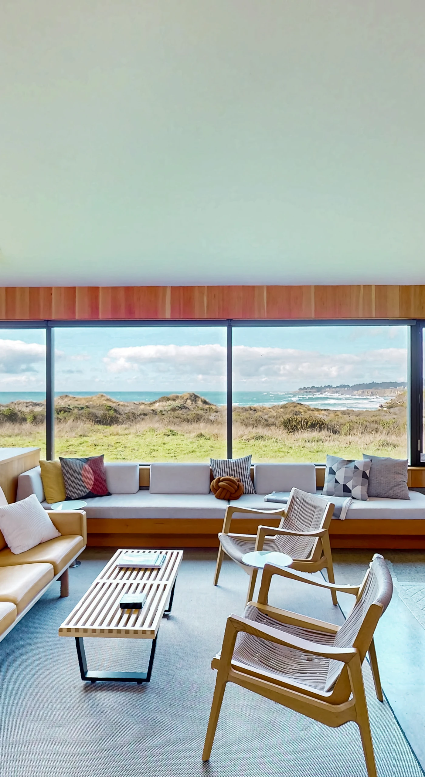Gaze out at the ocean while lounging in style; this spacious living room invites you to unwind with a cozy wood-burning fireplace.