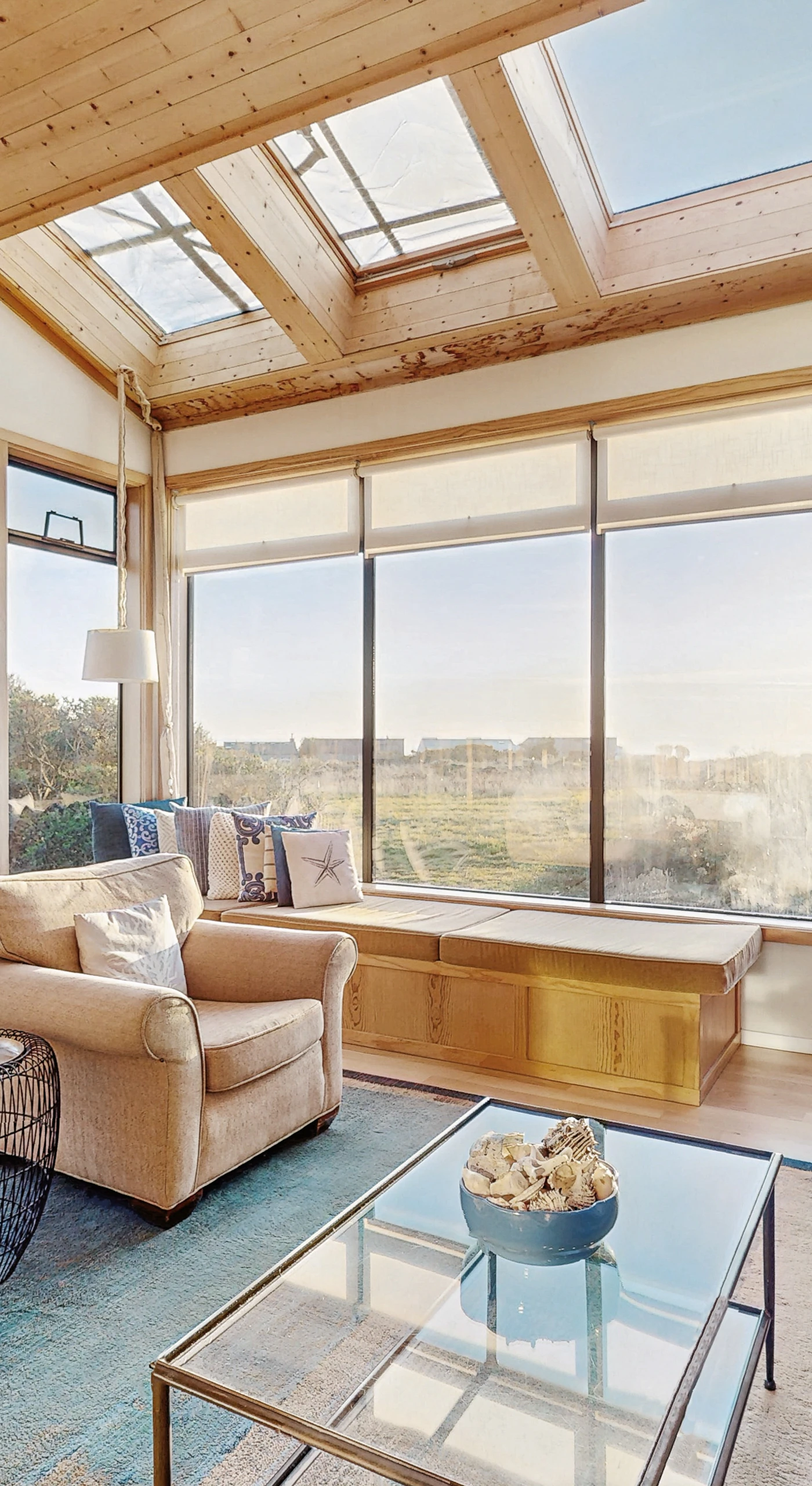 Large windows fill this sunlit living area with natural light, creating a perfect backdrop for relaxation and connection with nature.