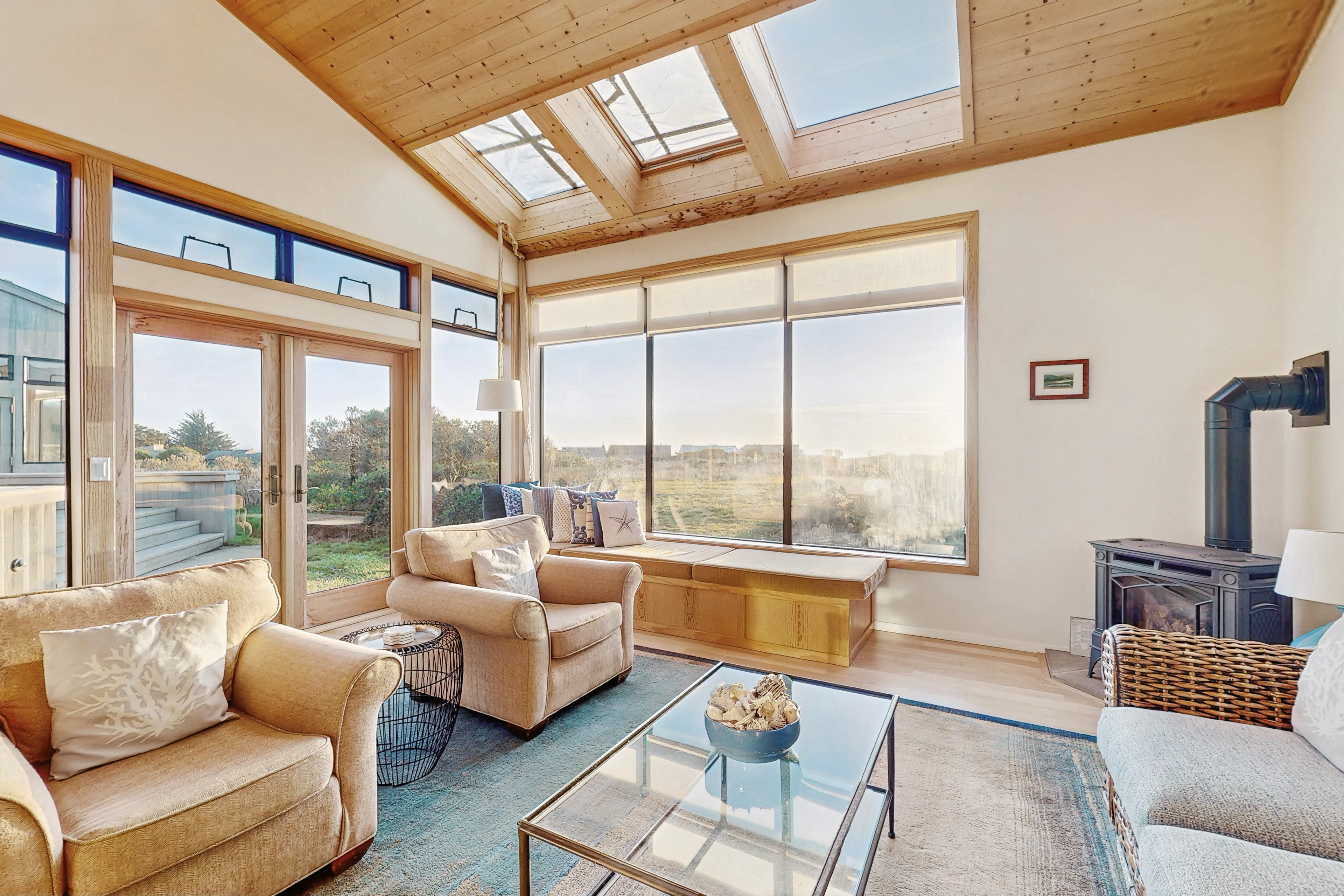 Large windows fill this sunlit living area with natural light, creating a perfect backdrop for relaxation and connection with nature.