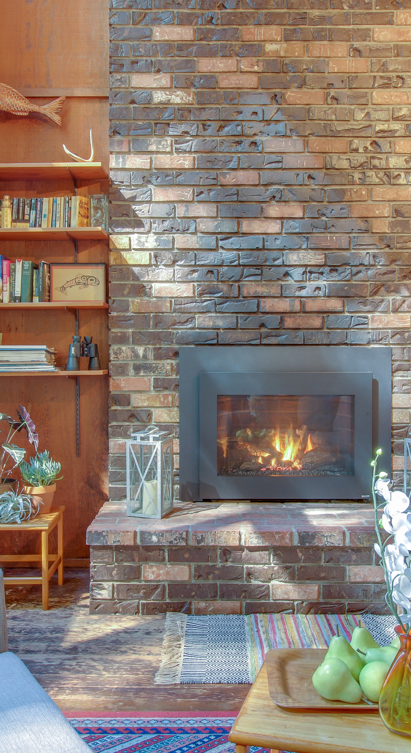 Cozy up by the gas fireplace in this inviting living room, where nature’s beauty spills in through large windows.