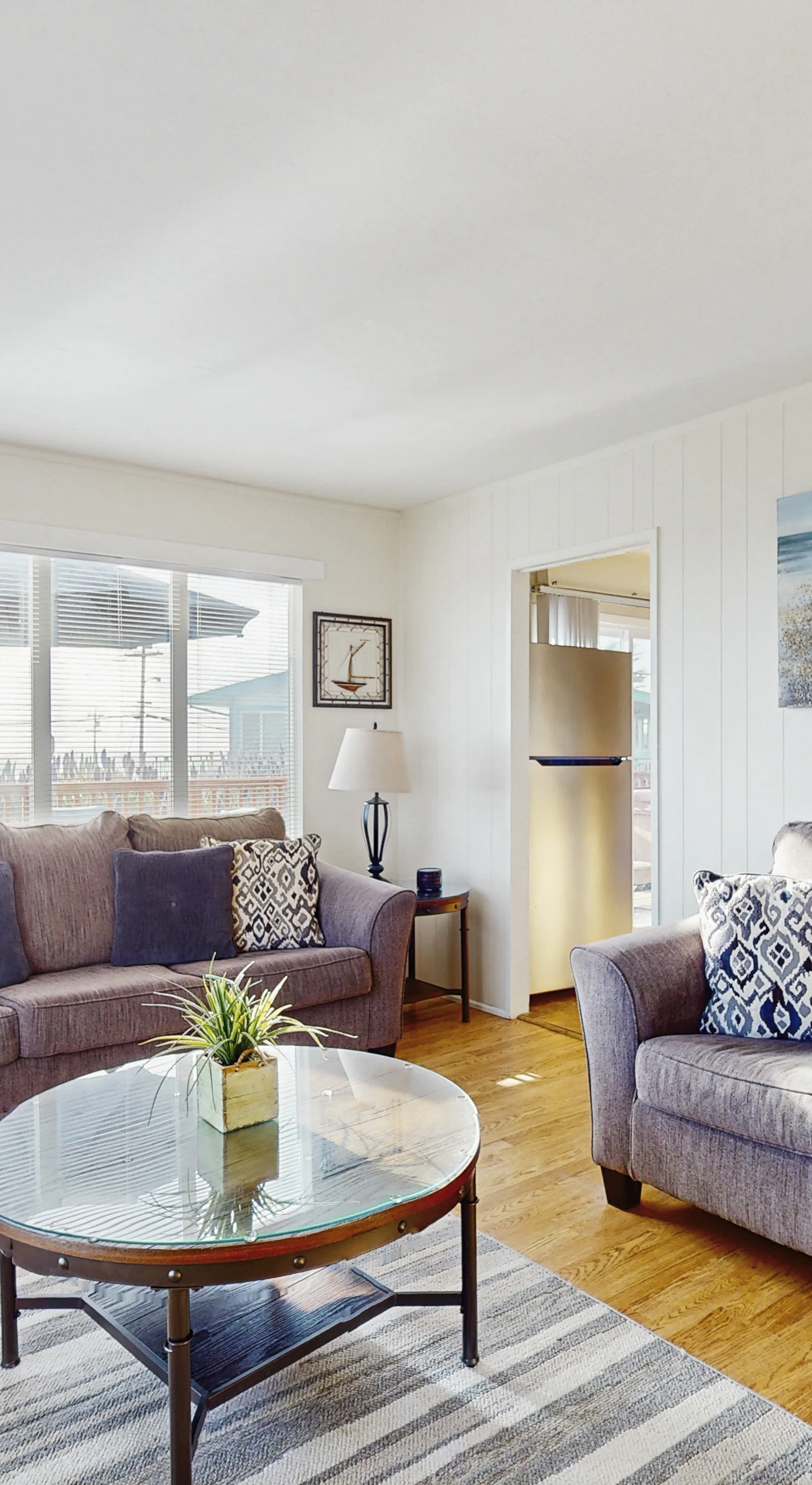 Sink into plush coastal-chic sofas surrounded by ocean-inspired artwork in your sunlit Bodega Bay living room — the perfect spot to unwind after a day exploring the Sonoma Coast.