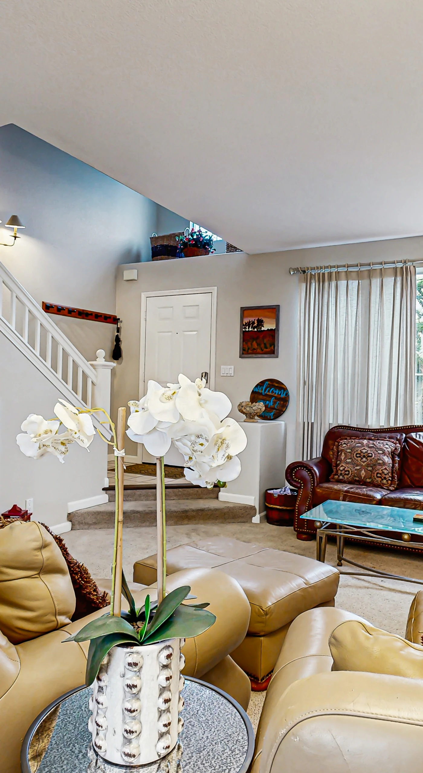 Gather your group in this inviting living space with ample seating, a curated bookshelf, and elegant orchid accents — ideal for planning your next wine country adventure.