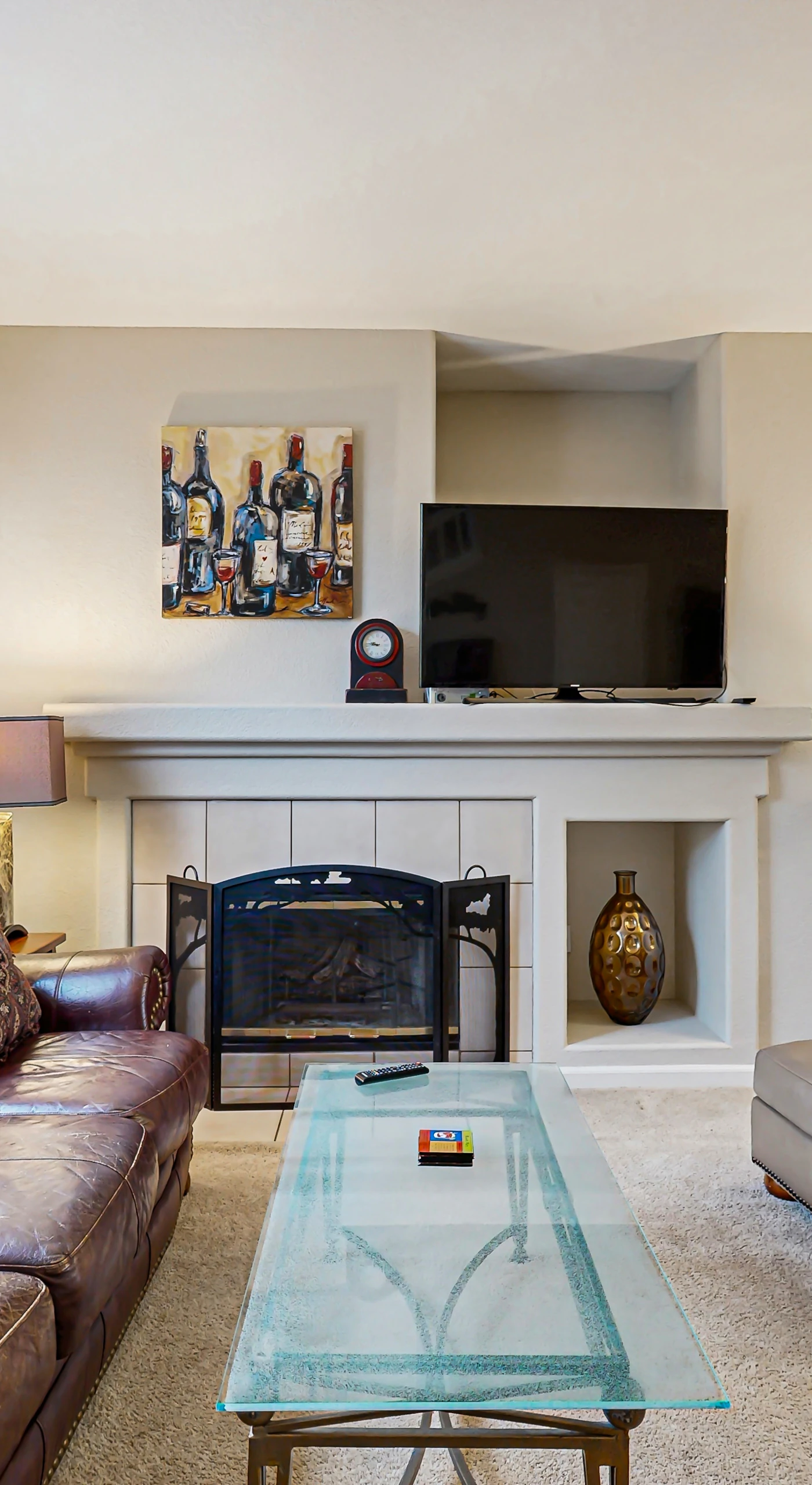 Sink into plush leather seating by the gas fireplace after a day exploring Sonoma vineyards — your living room features a flat-screen TV and warm, curated decor throughout.