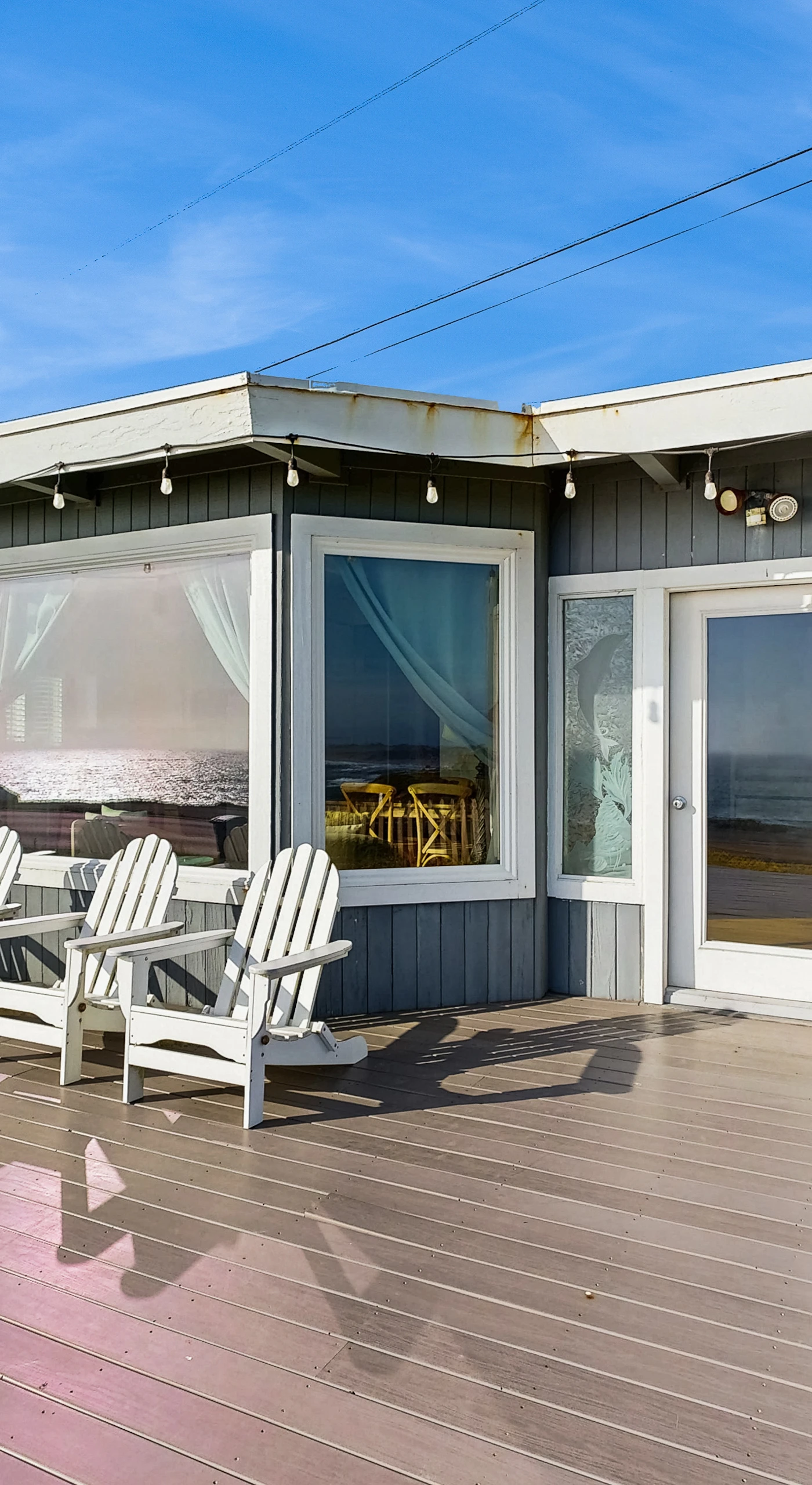 Relax on your private sun-drenched deck with Adirondack chairs and string lights at this Bodega Bay coastal retreat