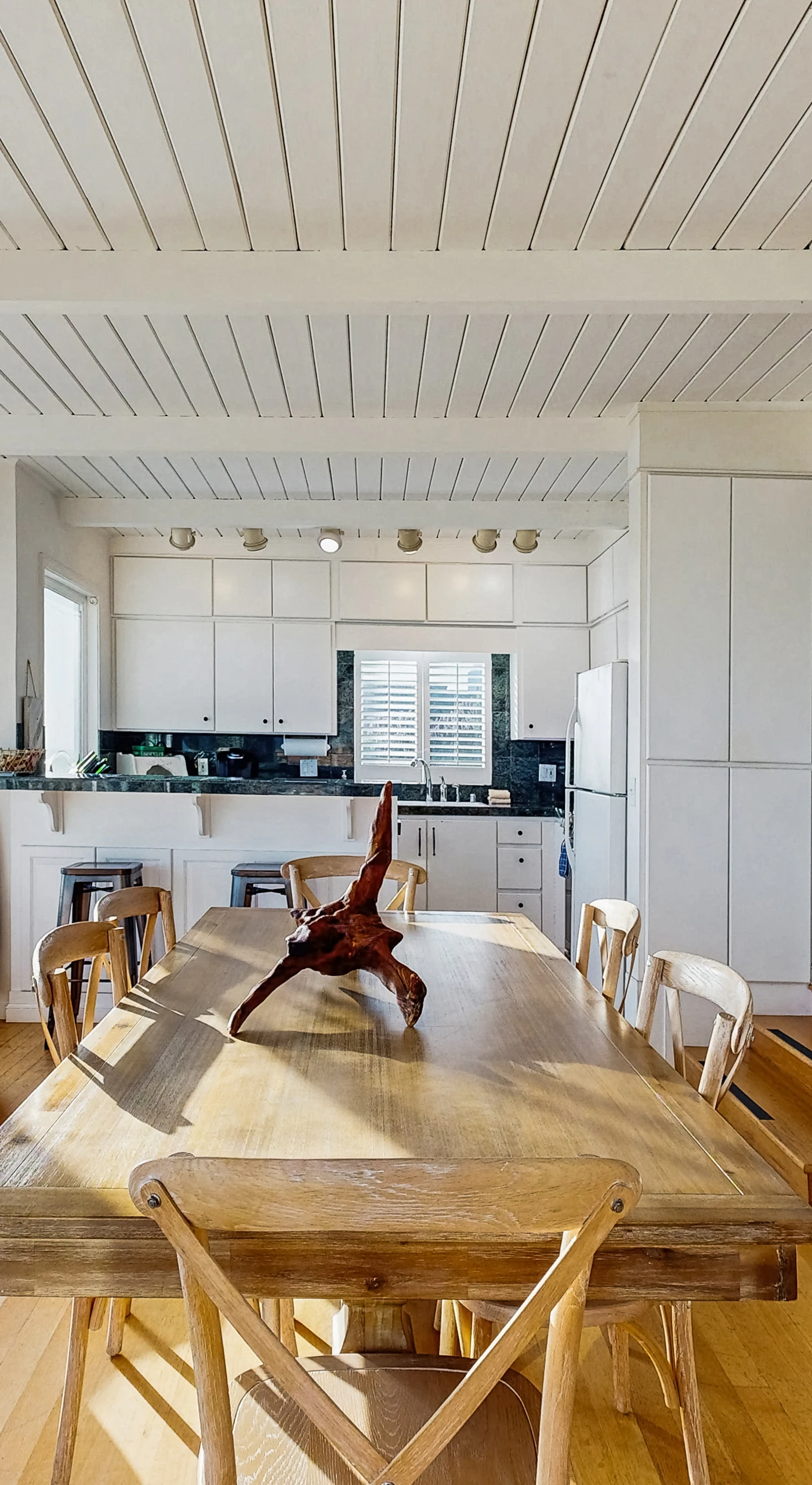 Enjoy dinner by the wood-burning fireplace in your open-concept living and dining space with ocean glimpses