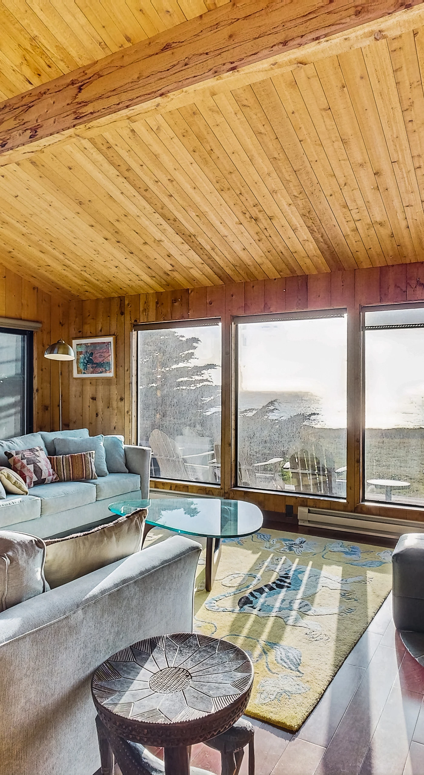 Bask in the warmth of natural wood and stunning ocean views as you relax in the inviting living room, perfect for unwinding after a day of coastal adventures.