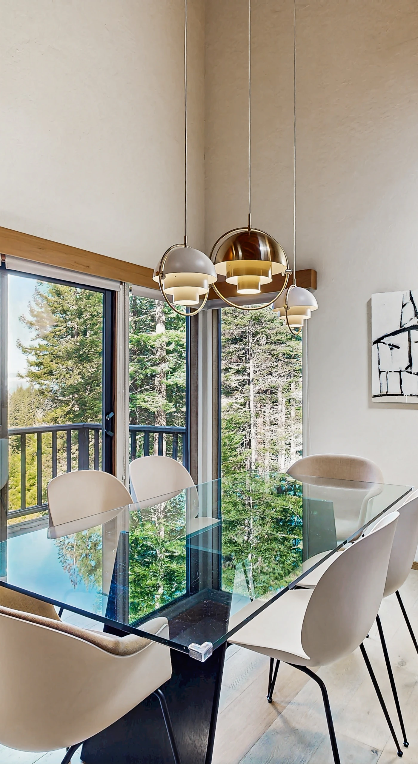 Dine with a view! Enjoy your meals at this elegant table, where large windows let in the beauty of the surrounding forest.