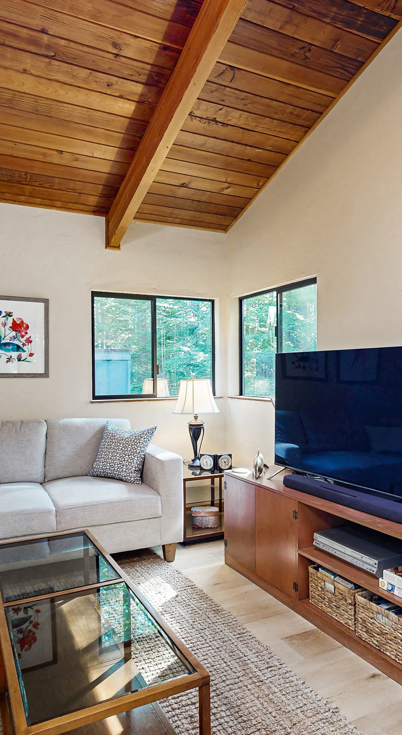 Gather with loved ones in the cozy living room, where natural light and wooden beams create an inviting space for relaxation and laughter.
