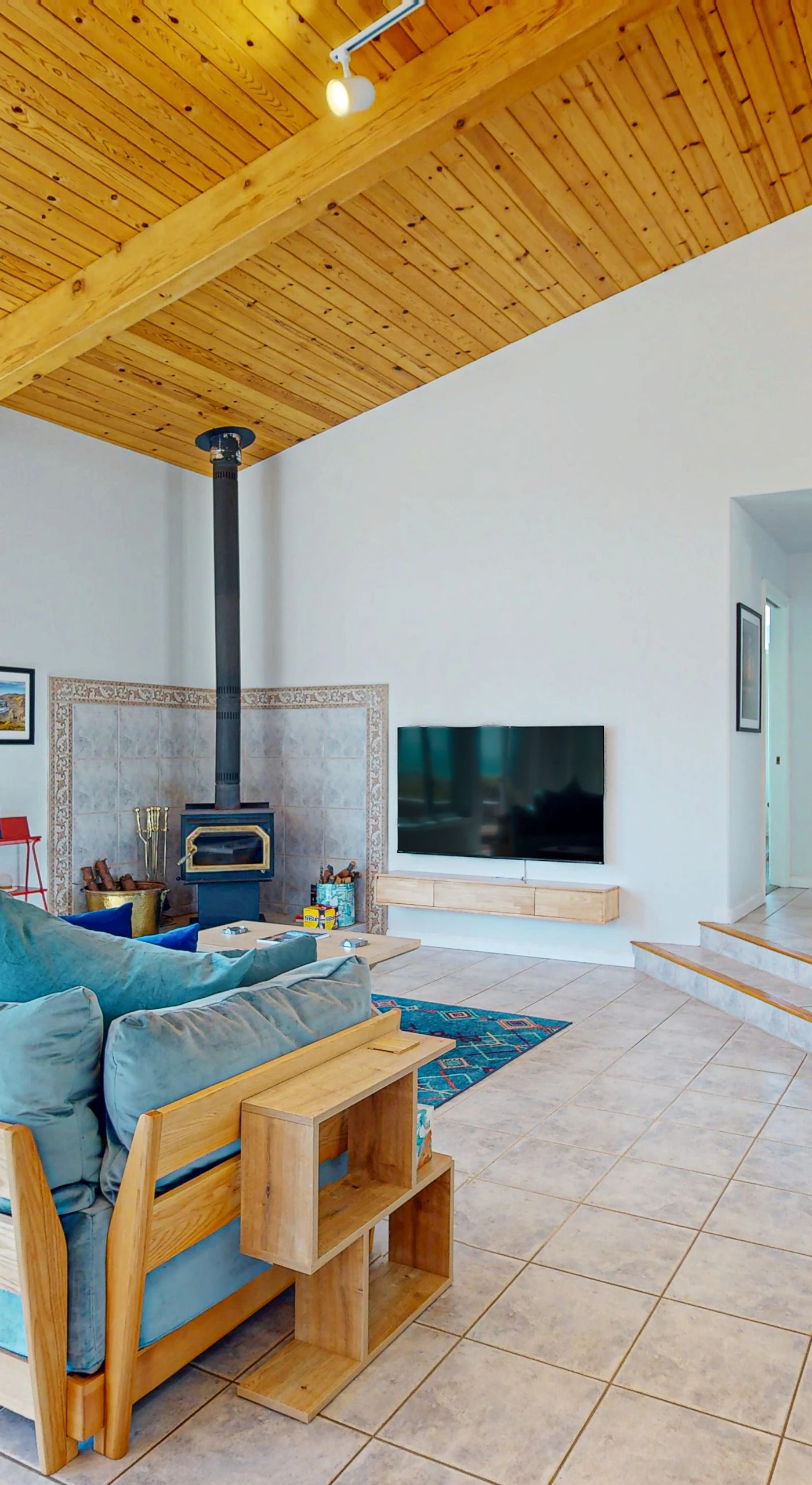 Cozy up by the wood stove in the living room, a perfect spot for sharing stories after a day of coastal adventures.