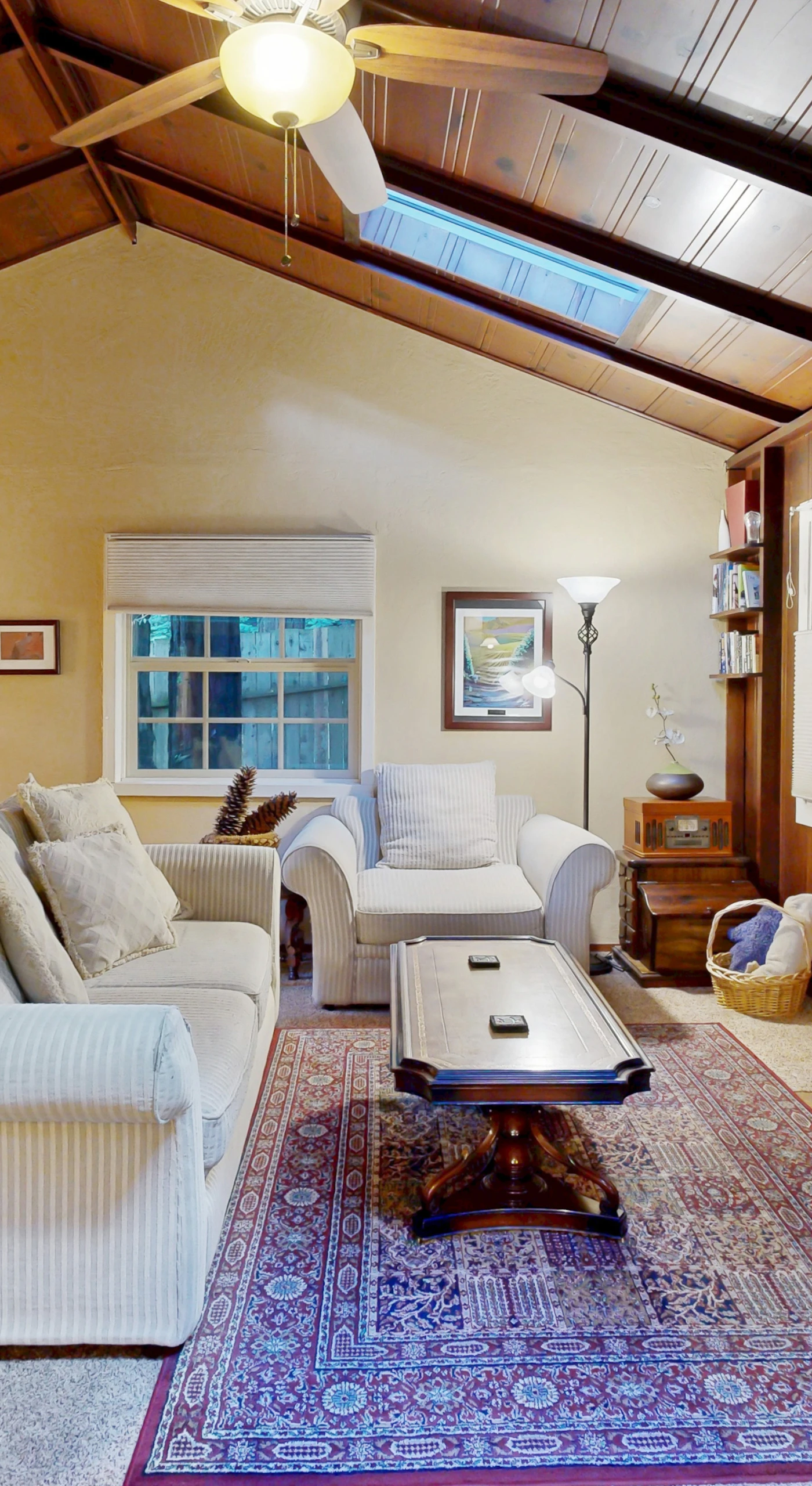 Gather around the gas fireplace in this vaulted-ceiling living room with skylights, plush sofas, and a curated book collection.