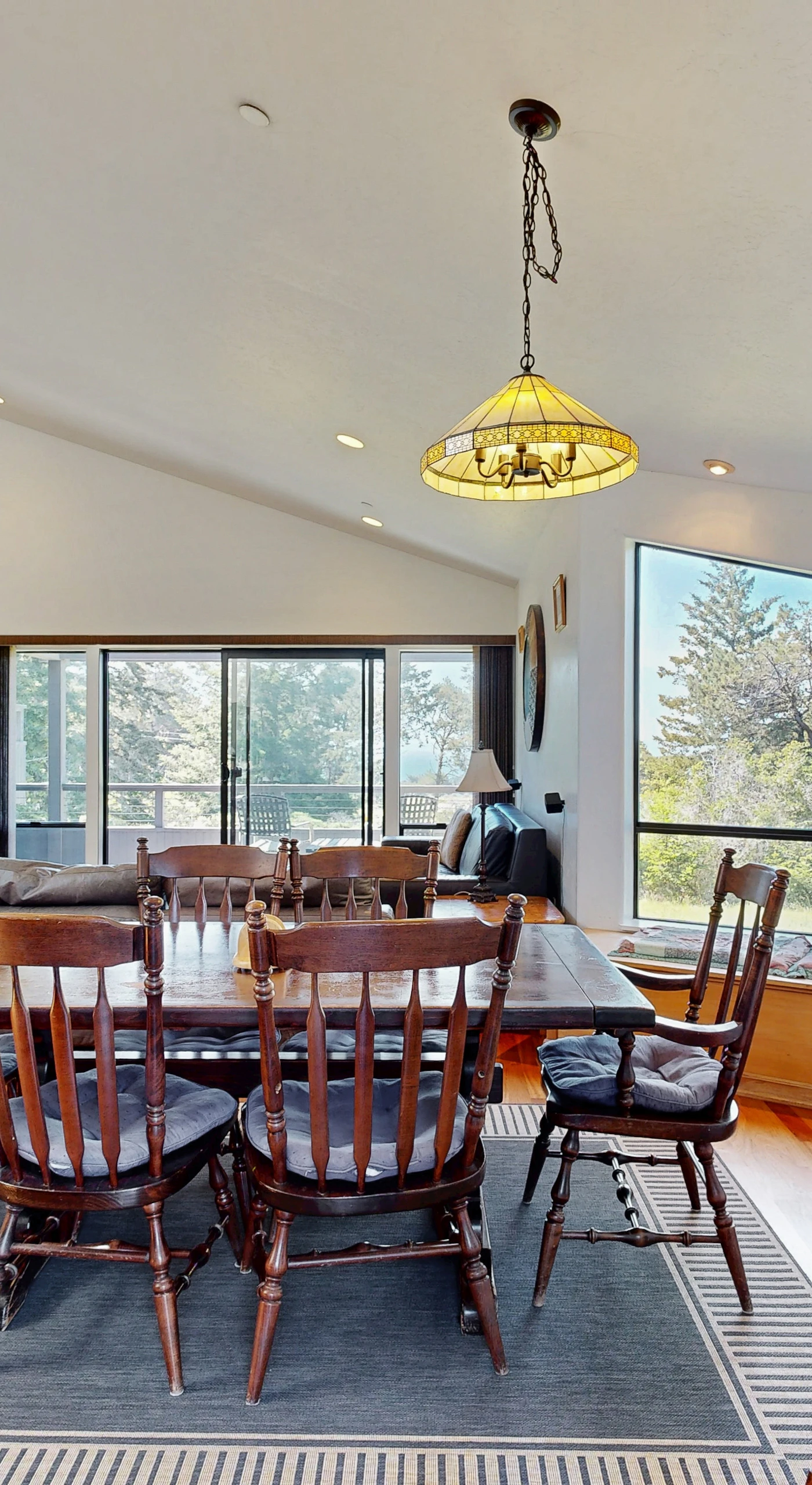 Gather around the large dining table for unforgettable meals, with sunlight streaming in and nature just outside the window.