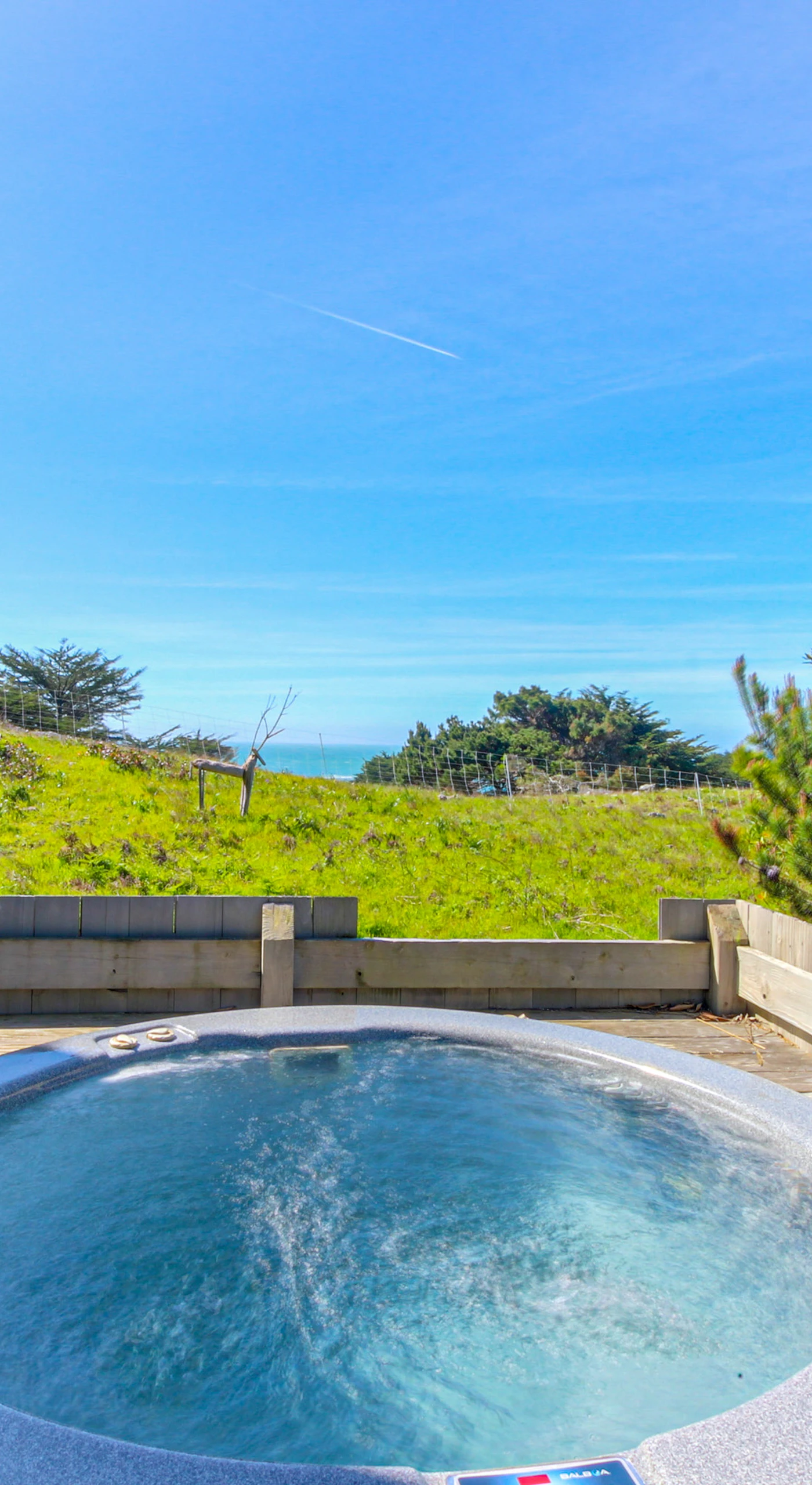 Soak in the private hot tub with stunning ocean views, the perfect spot for relaxation after a day of exploration.