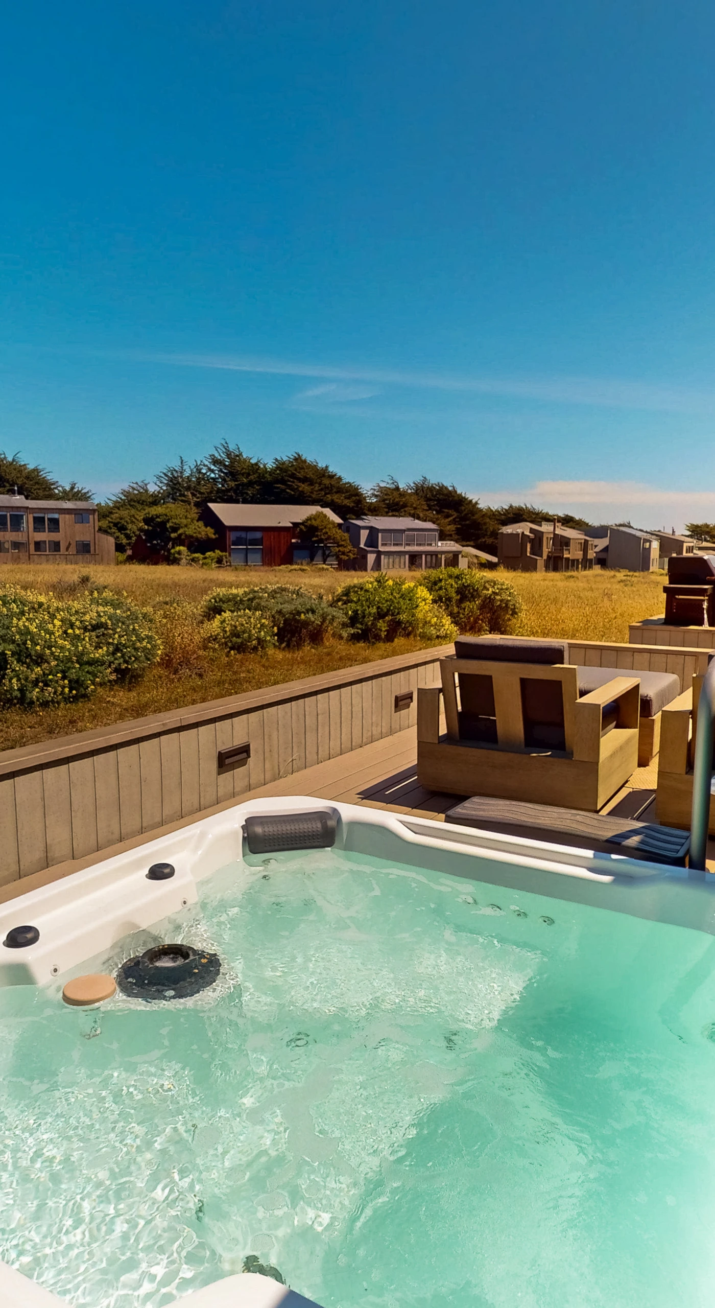 Relax in the private hot tub as you soak in the stunning coastal landscape around you.