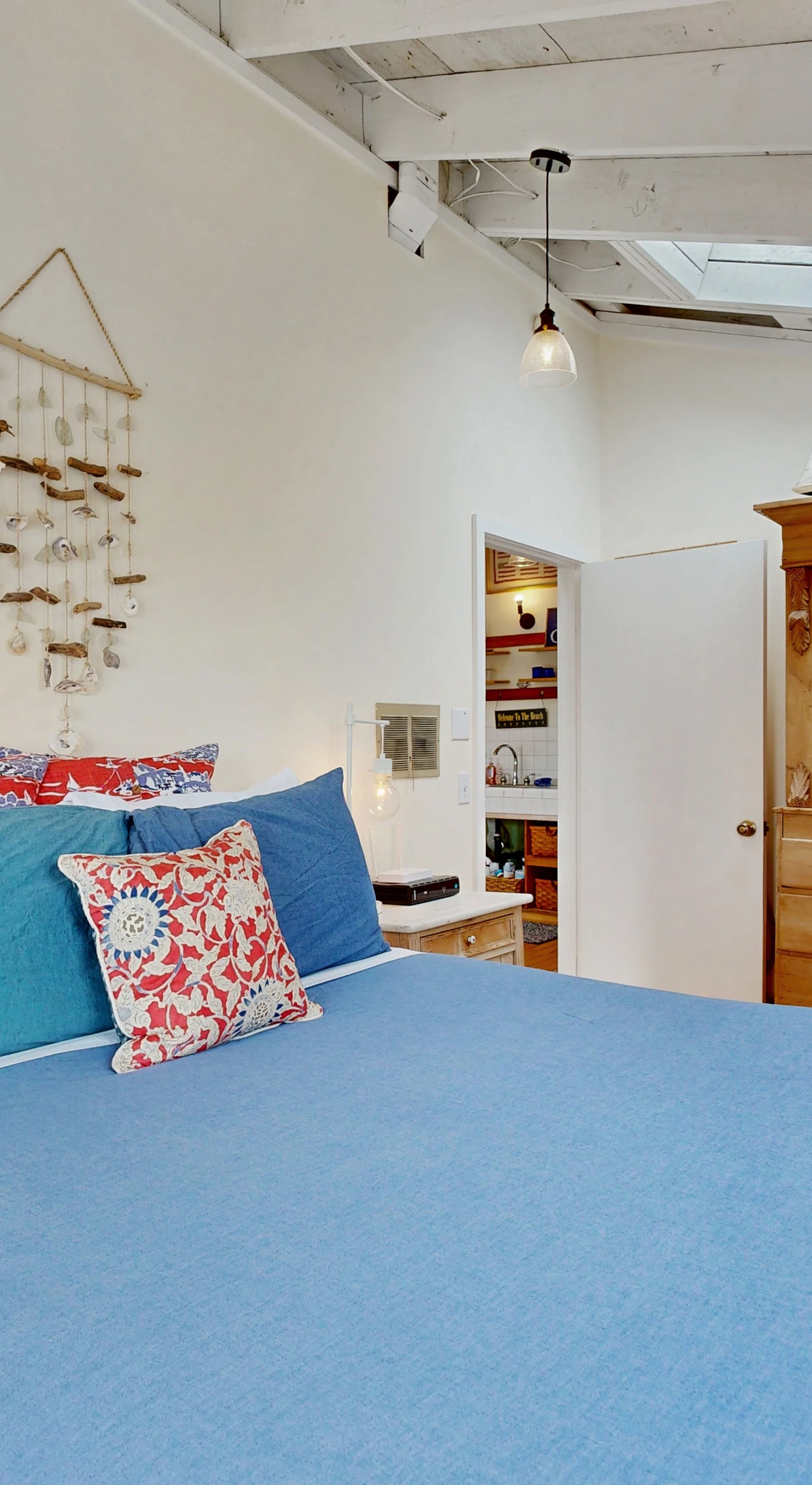 Wake to soft light filtering into your cozy bedroom, appointed with a wooden armoire and beachy accents throughout.