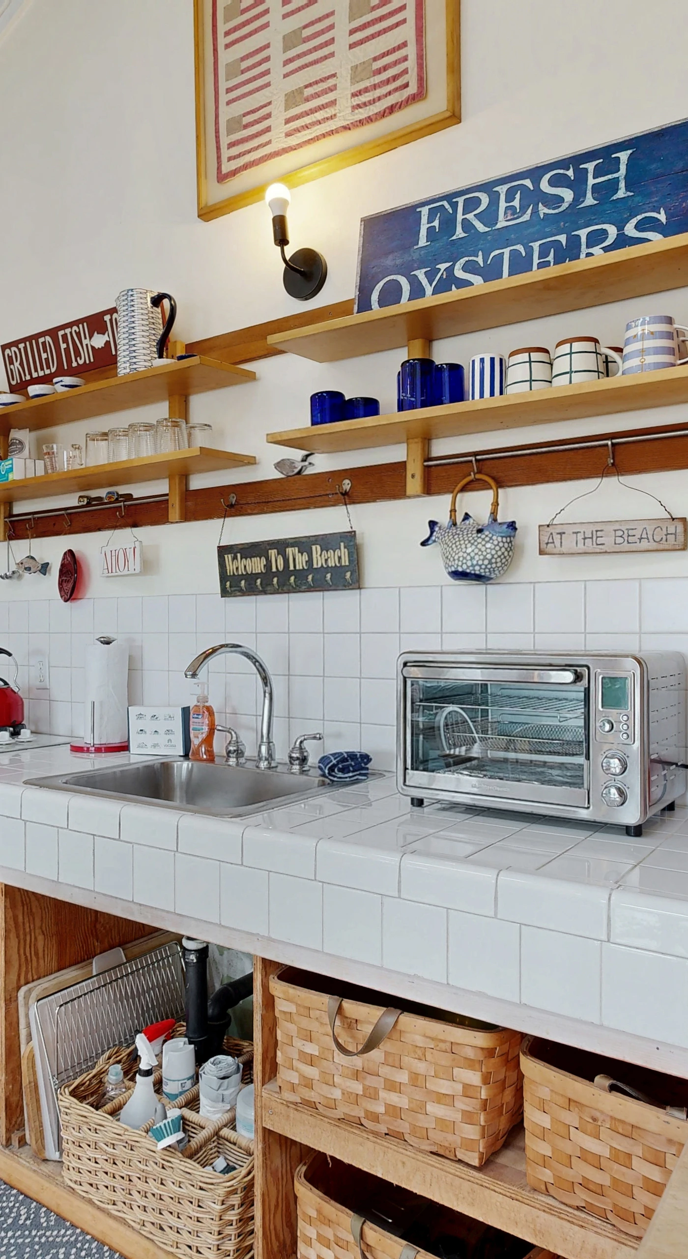Well-equipped counter with coffee maker, toaster oven, and stainless appliances — everything you need for your coastal morning routine.
