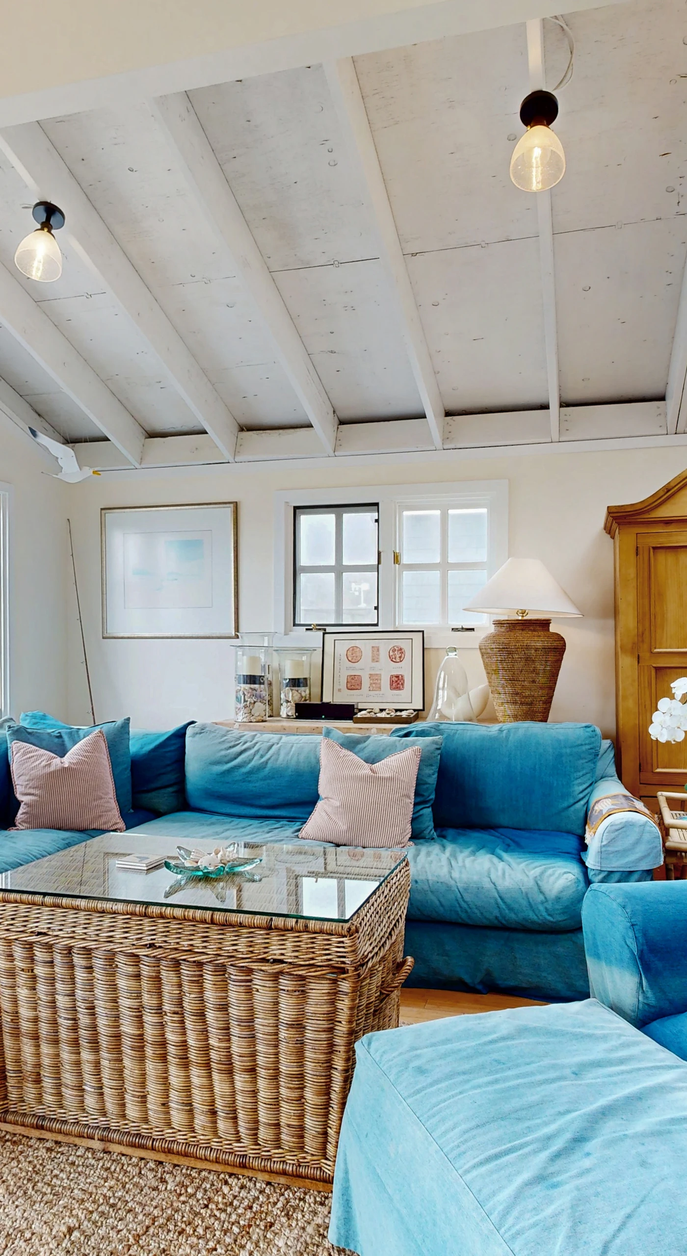 Sink into plush blue sofas beneath vaulted beam ceilings in this sun-drenched Bodega Bay living room — your coastal retreat starts here.