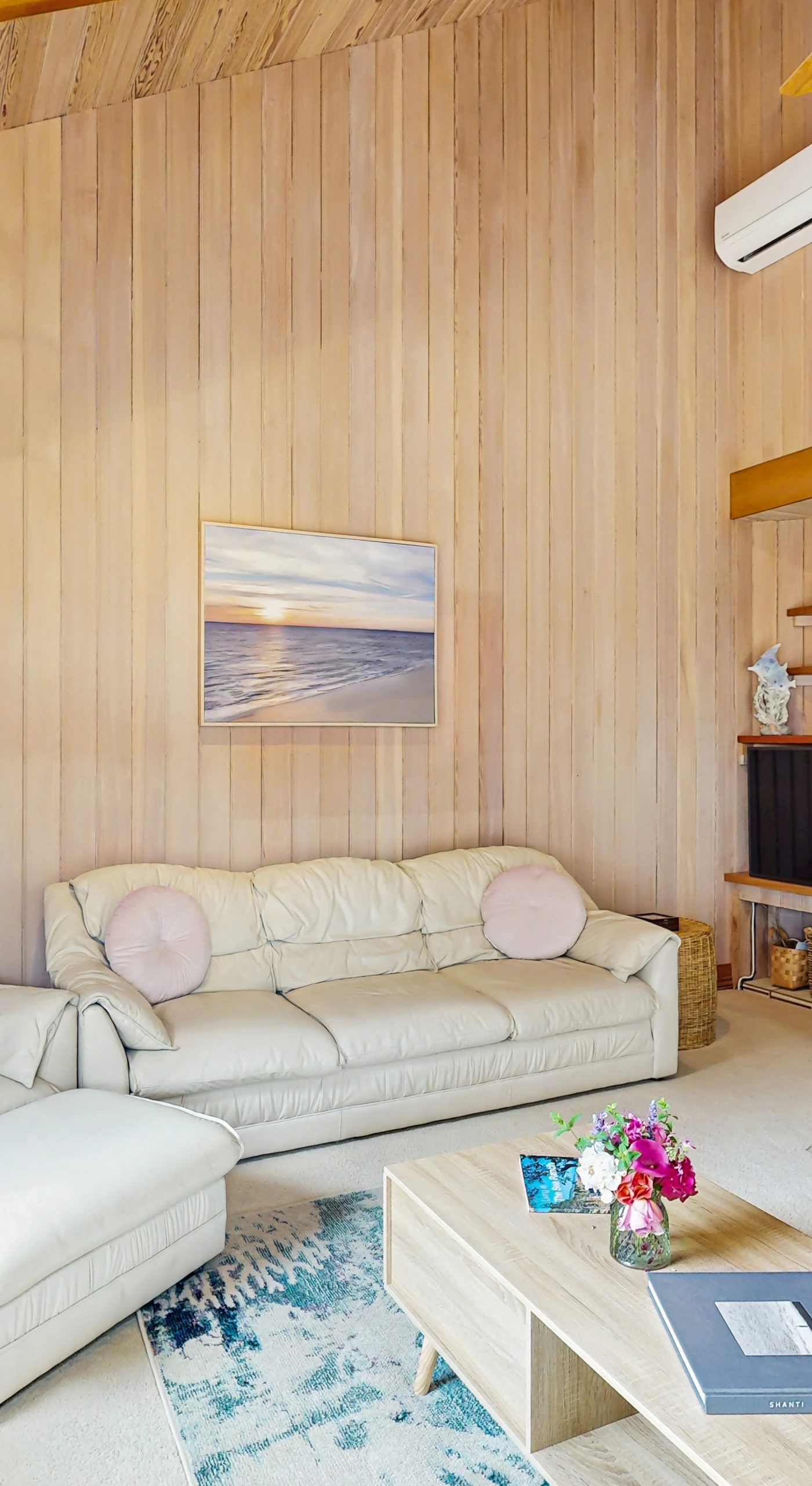 Enjoy movie nights or cozy conversations in this spacious living room, featuring a stone fireplace and ample seating.