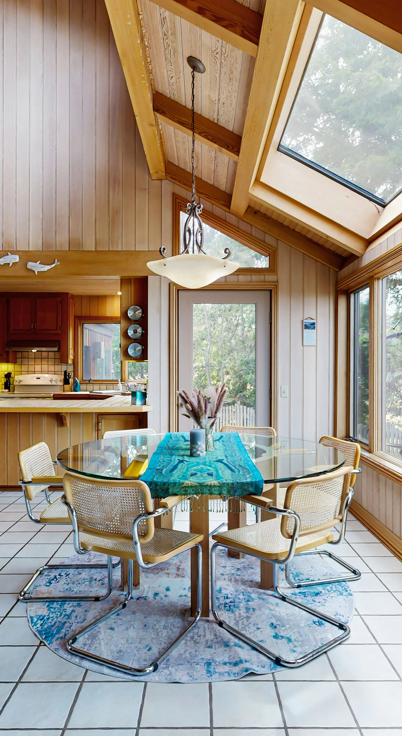 Dine with a view in this sunlit dining area, where large windows invite the beauty of nature inside for memorable meals with loved ones.
