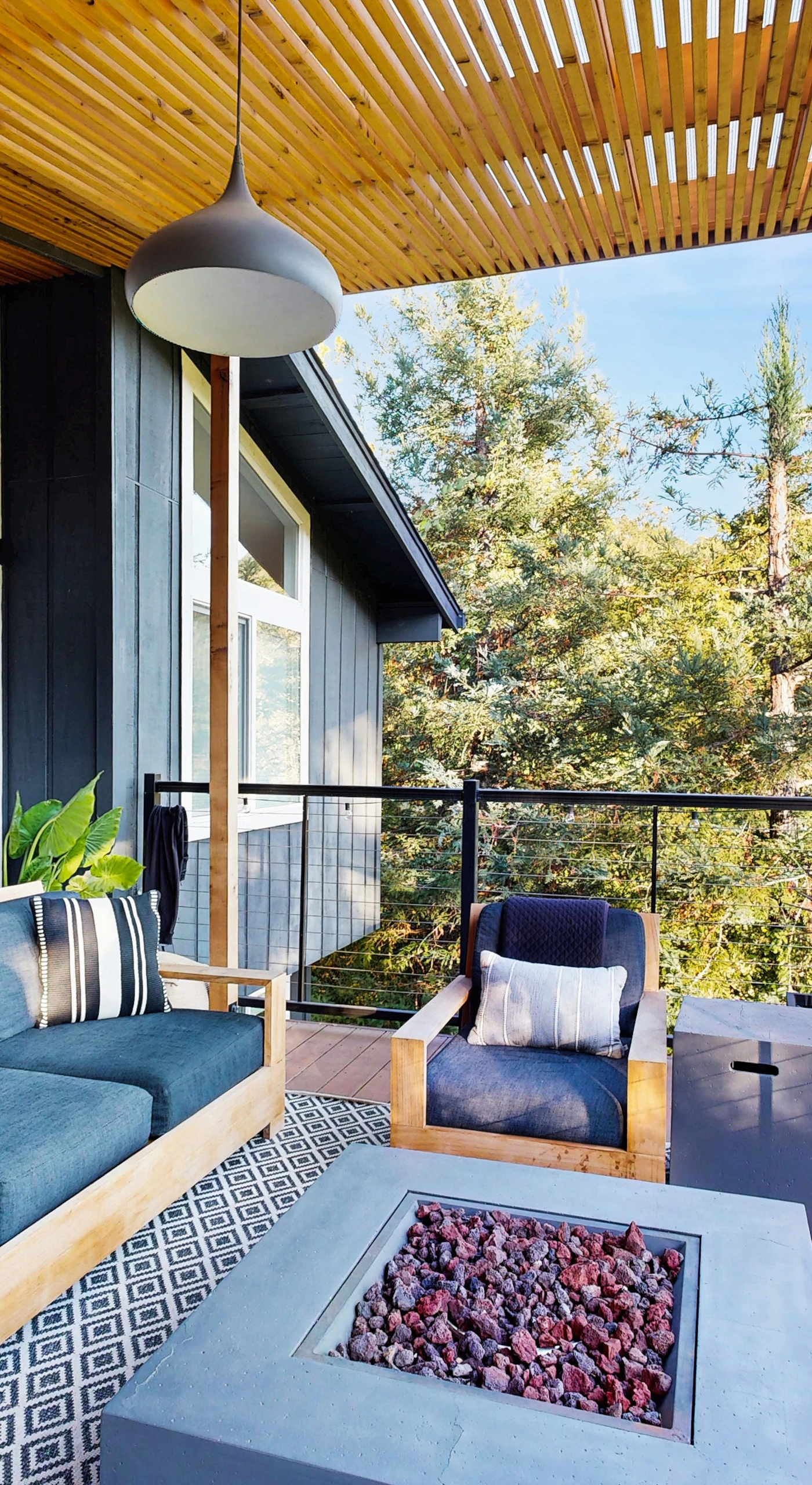 Covered deck lounge with plush seating and a fire pit table framing mountain views — your Healdsburg evening ritual starts here.