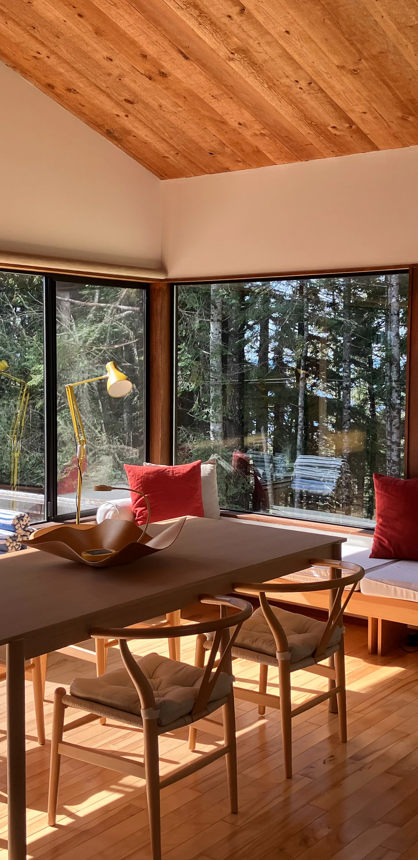 Dine surrounded by nature, with sunlight streaming through expansive windows and the tranquil sounds of the forest just outside.