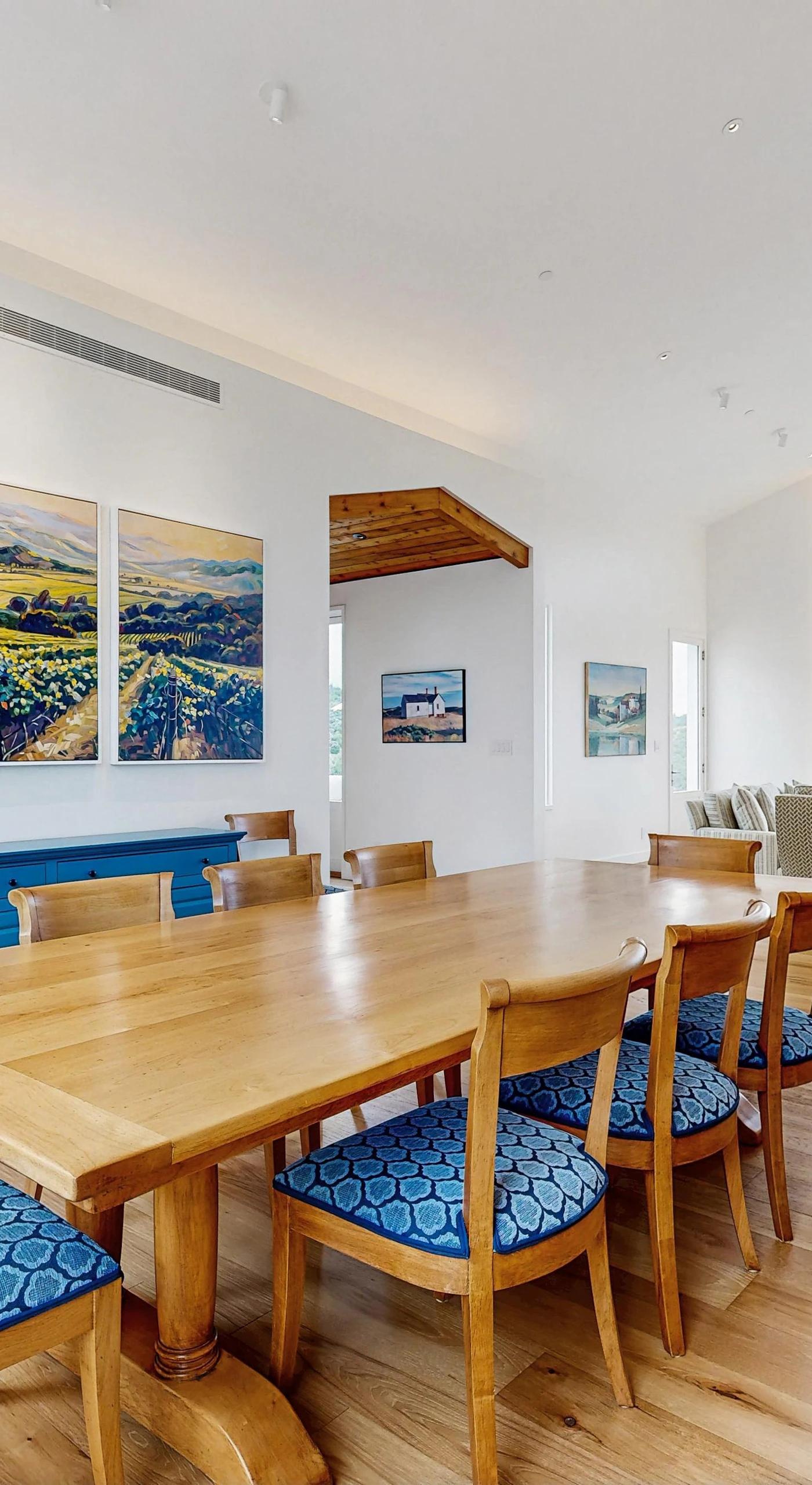 Gather your group around this elegant dining table beneath vineyard-inspired artwork — your private tasting room for unforgettable Sonoma wine country dinners.