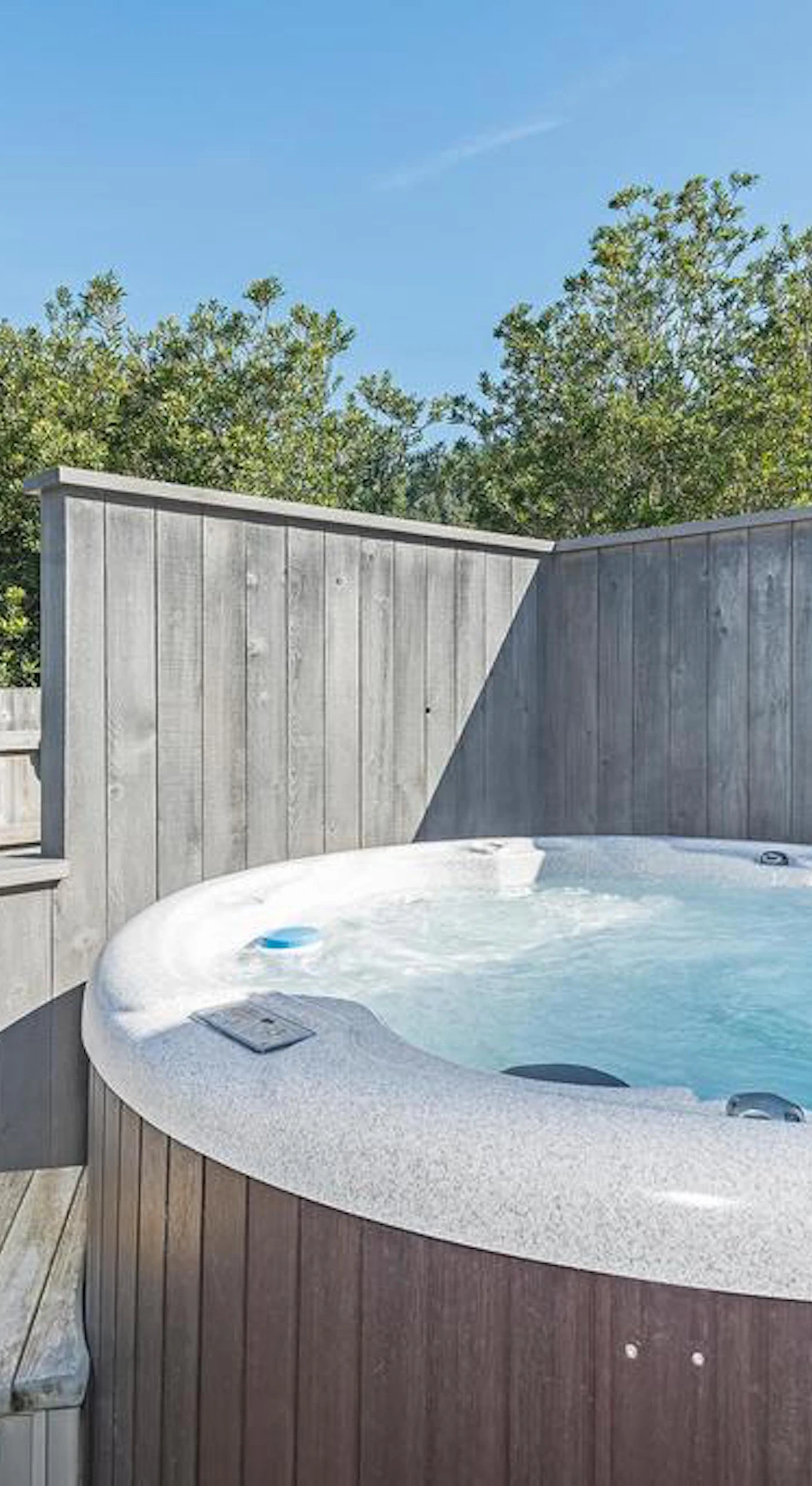 Soak under the stars in your private hot tub, a perfect retreat after a day of coastal adventures.