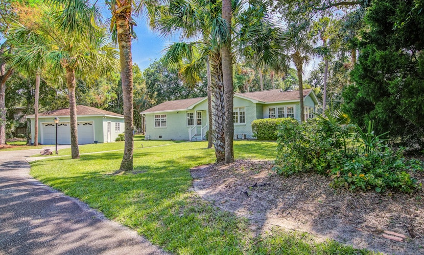 Refined coastal home surrounded by palms with large deck & athletic court access