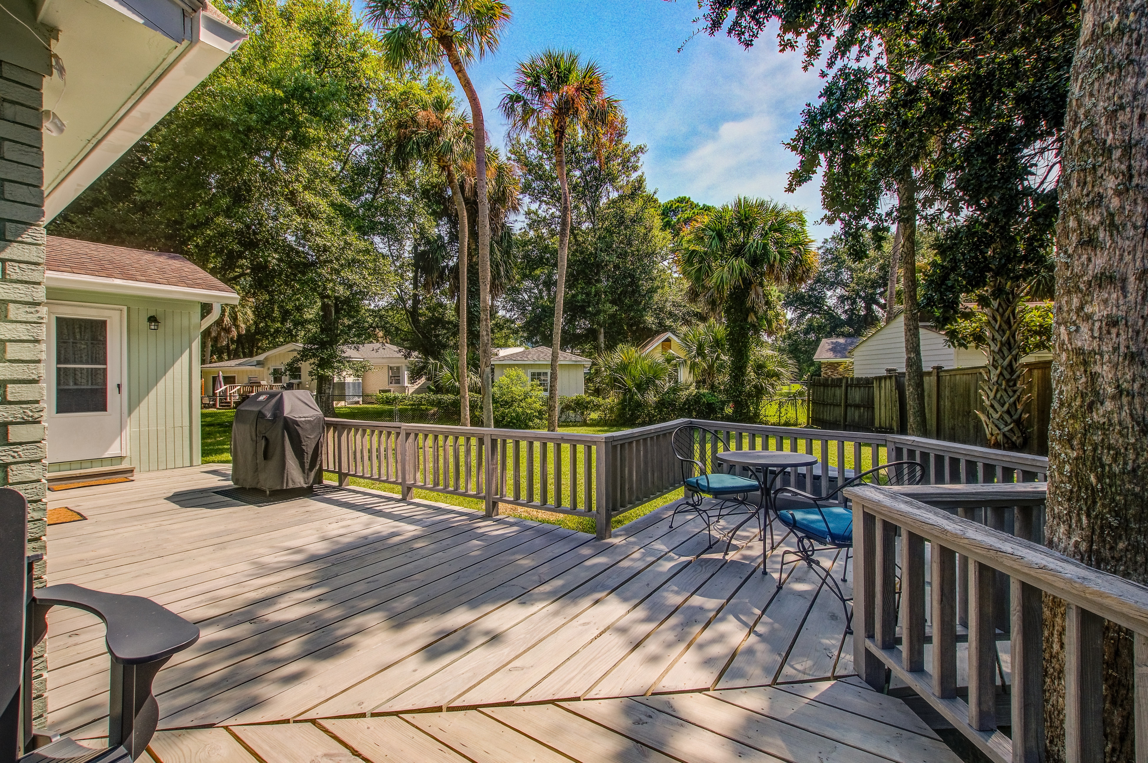 Refined coastal home surrounded by palms with large deck & athletic court access