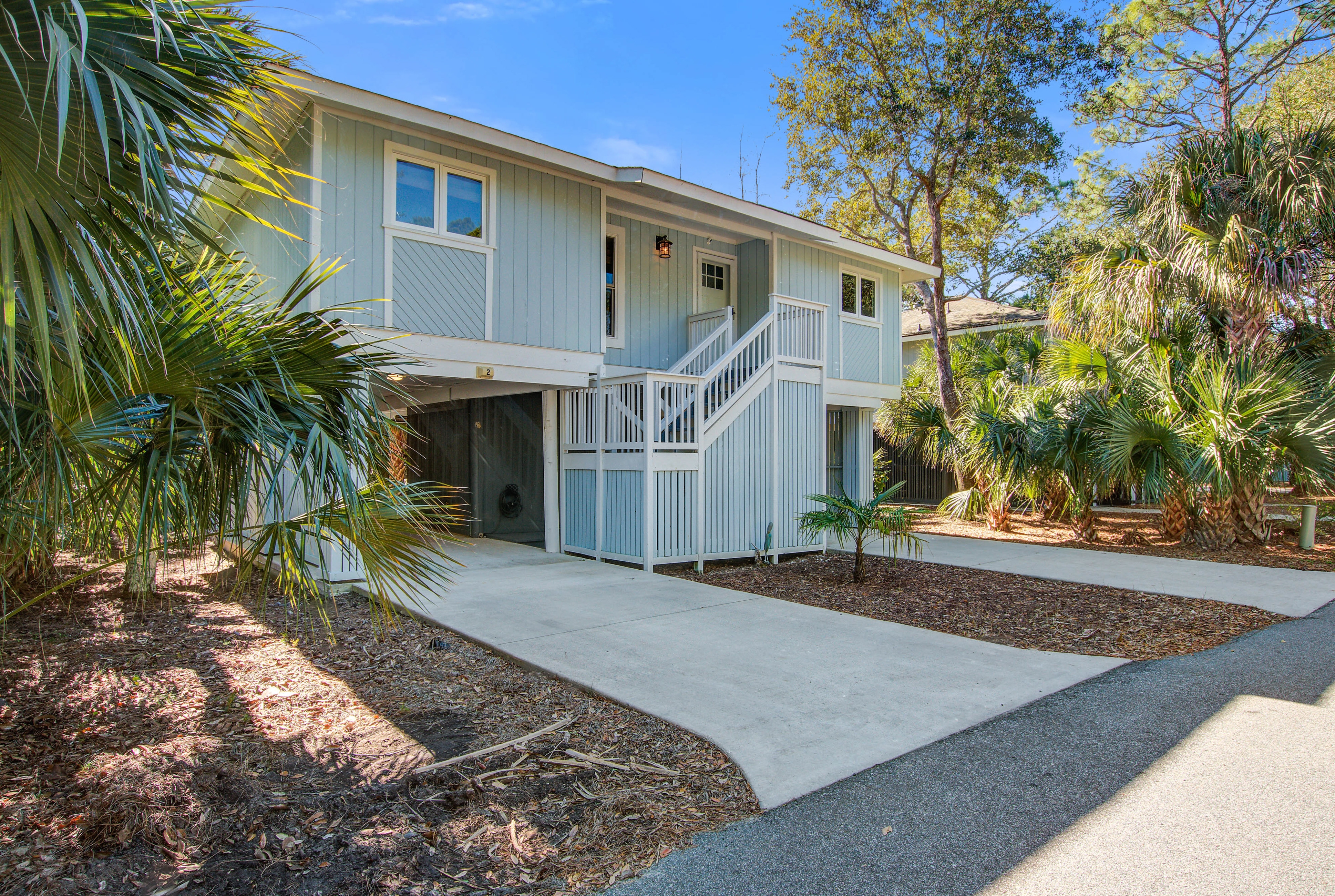 Palm-surrounded abode with screened-in balcony, chef's kitchen, smart TVs, & W/D