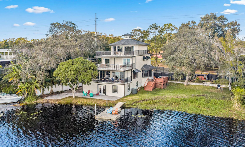 Sprawling river view estate with game room dock kayaks grill and fishing gear
