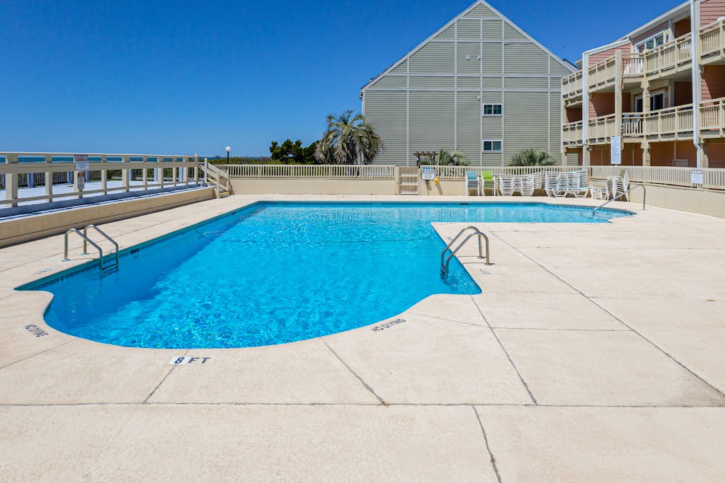 Updated third-floor condo with WiFi, shared pool, balcony, W/D, & central AC