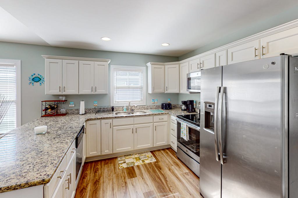 Updated home near the beach with fenced yard, grill, central AC, & washer/dryer