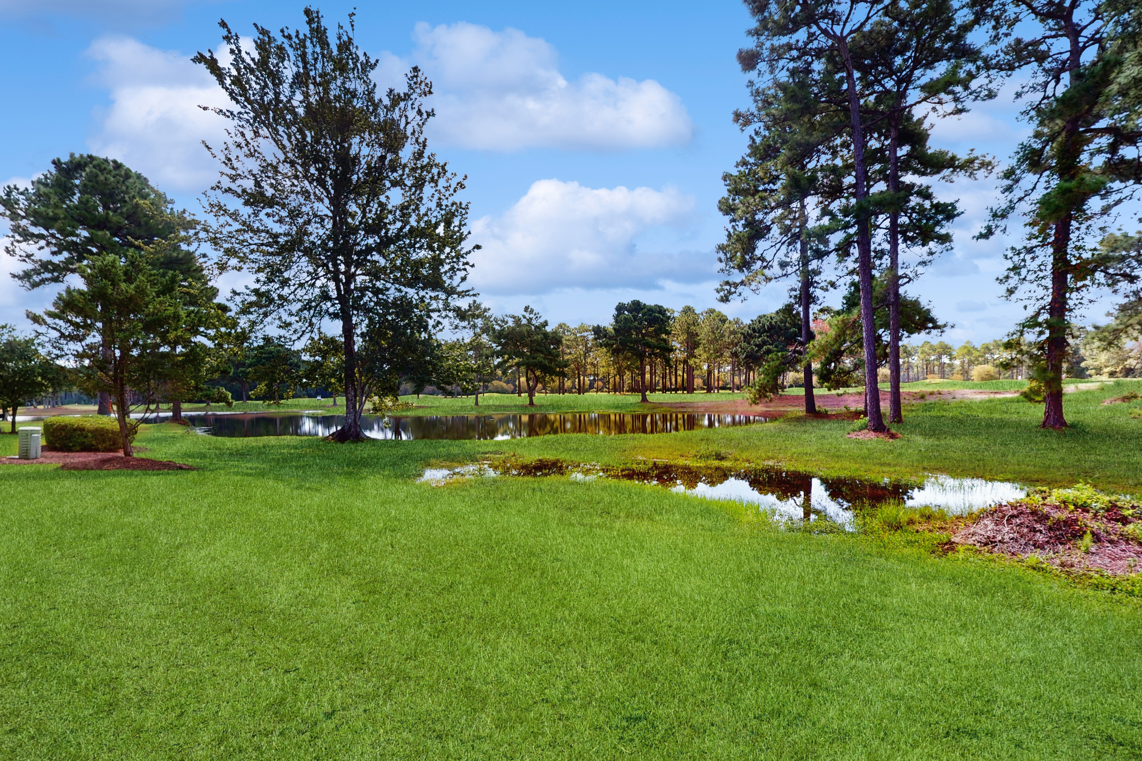 1st-floor corner condo with water view, on-site pool, & screened patio